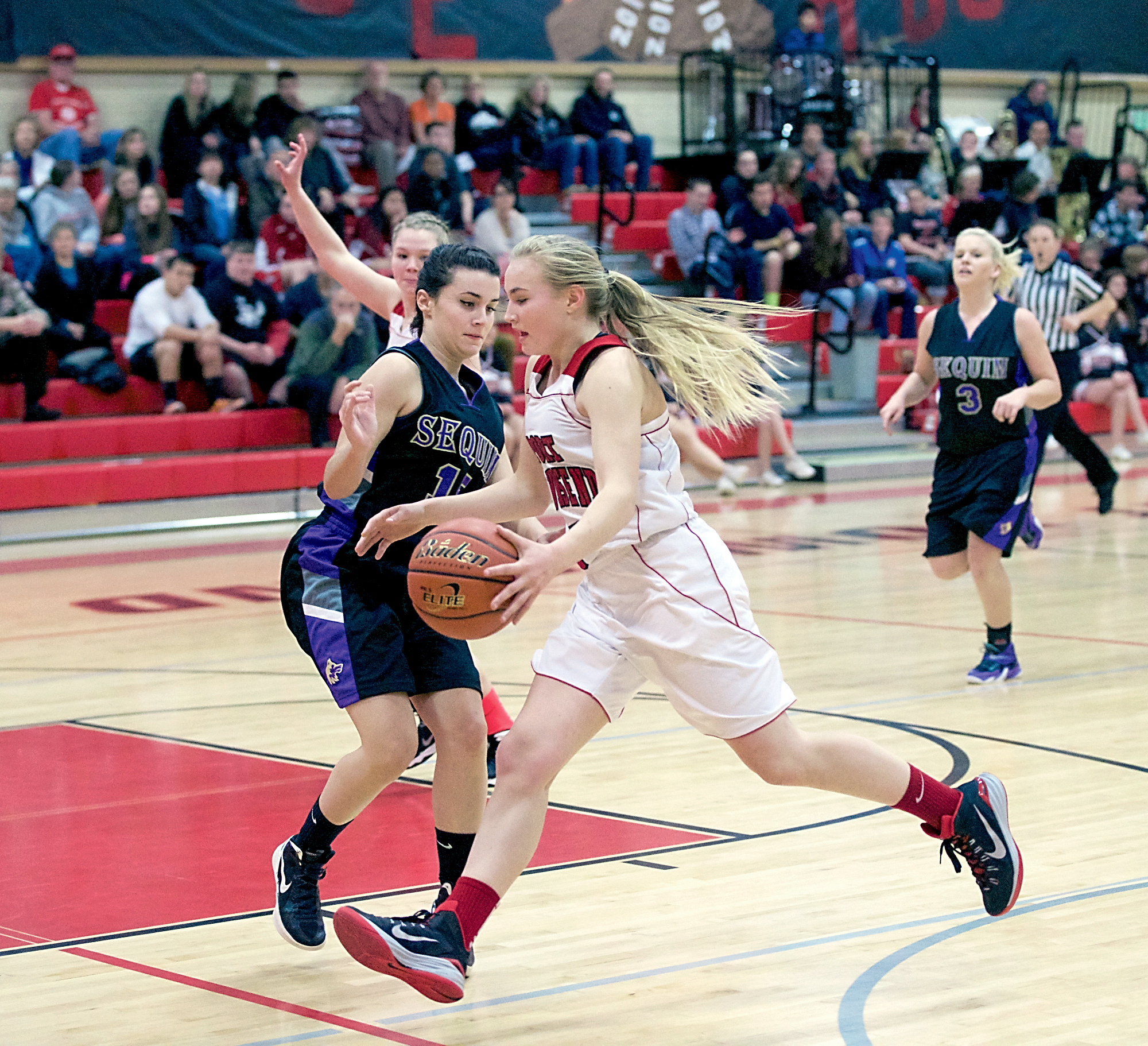 Port Townsend's Kaitlyn Meek (with ball) drives to the basket while guarded by Sequim's Katherine Landoni during the Wolves' 61-24 victory at Port Townsend High School on Monday. Steve Mullensky/for Peninsula Daily News