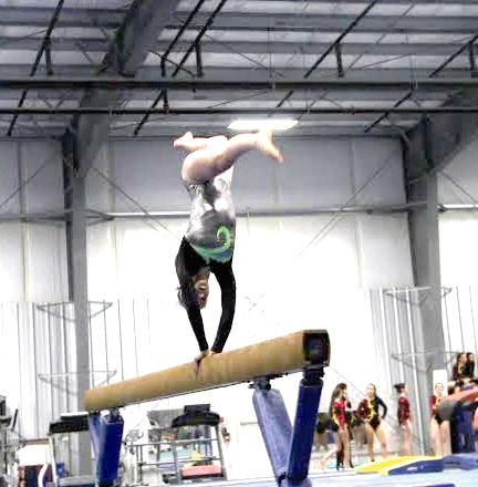 Port Angeles' Maya Wharton performs on the beam at Black Hills Gymnastics in Lacey.