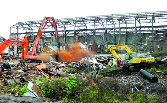 An excavator razes one of the huge mill buildings at the former Peninsula Plywood plant in Port Angeles. Keith Thorpe/Peninsula Daily News