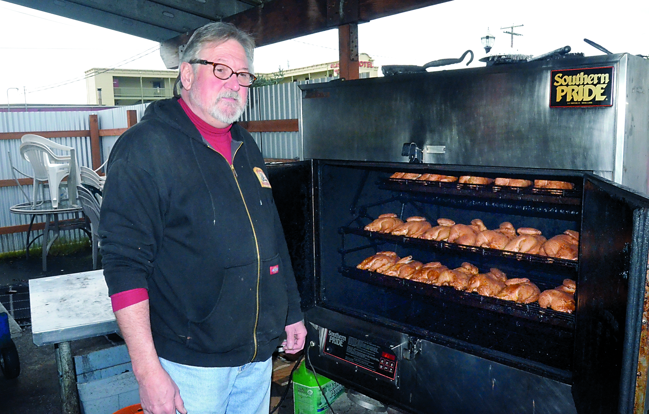 Larry Dennison inspects the last batch of chickens to be barbecued at his restaurant