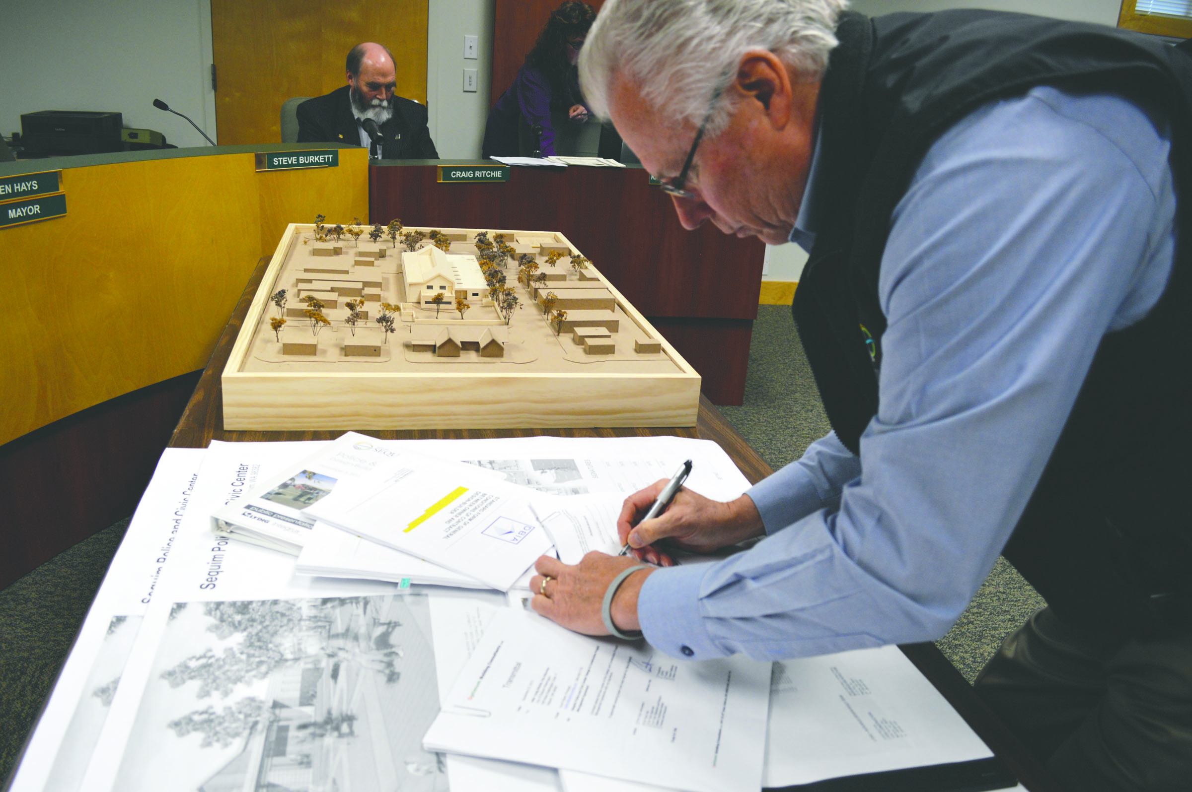 Sequim City Manager Steve Burkett signs a contract with Lydig Construction to begin work on the city’s new city hall and police station. Demolition work on the existing city hall is expected to start in March. — Joe Smillie/Peninsula Daily News