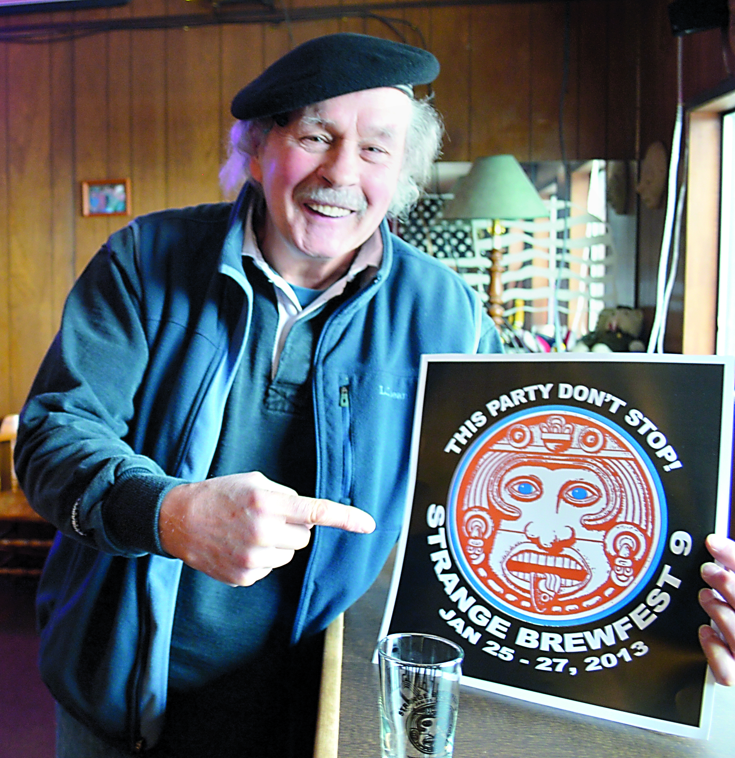 American Legion Post Cmdr. Joe Carey displays the Mayan-themed poster and souvenir tasting glass each Strange Brewfest attendee will receive with his or her admission.  -- Photo by Joe Smillie/Peninsula Daily News