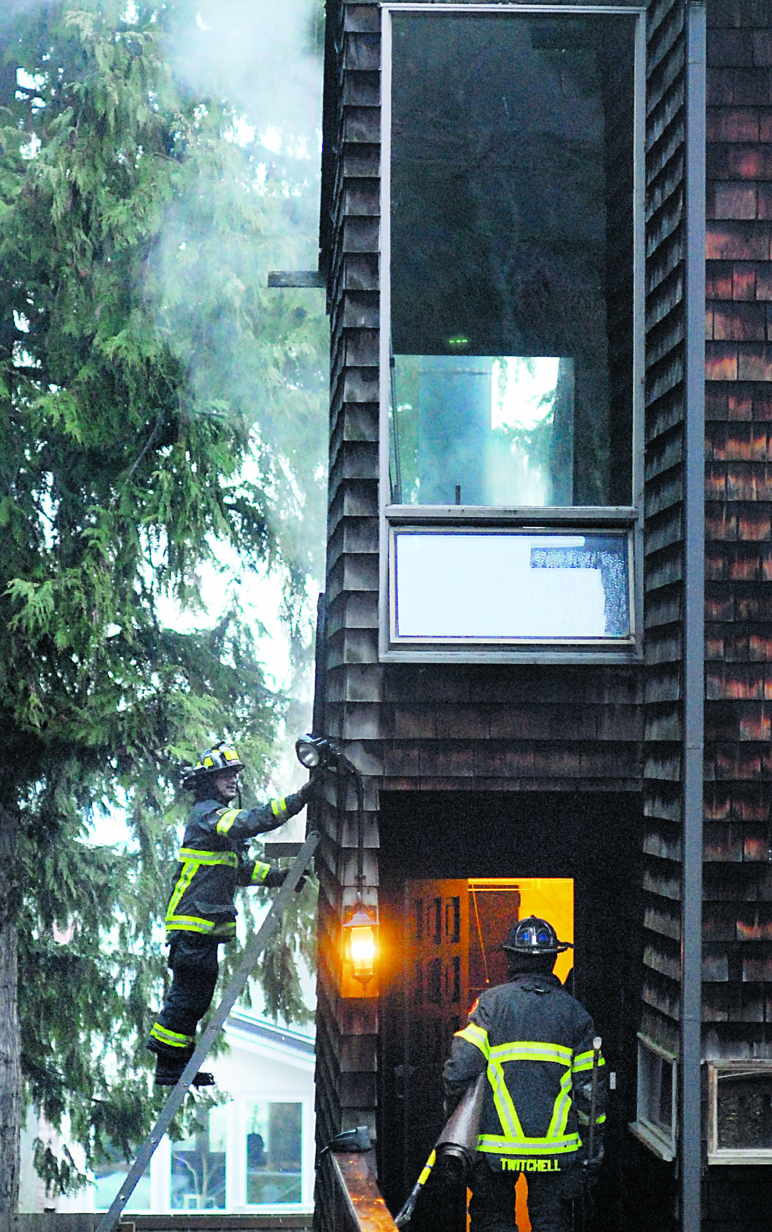 Port Angeles firefighters work to determine the extent of a chimney fire that spread into the adjoining attic of a house at 1603 E. Fifth St. in Port Angeles on Wednesday afternoon. Keith Thorpe/Peninsula Daily News