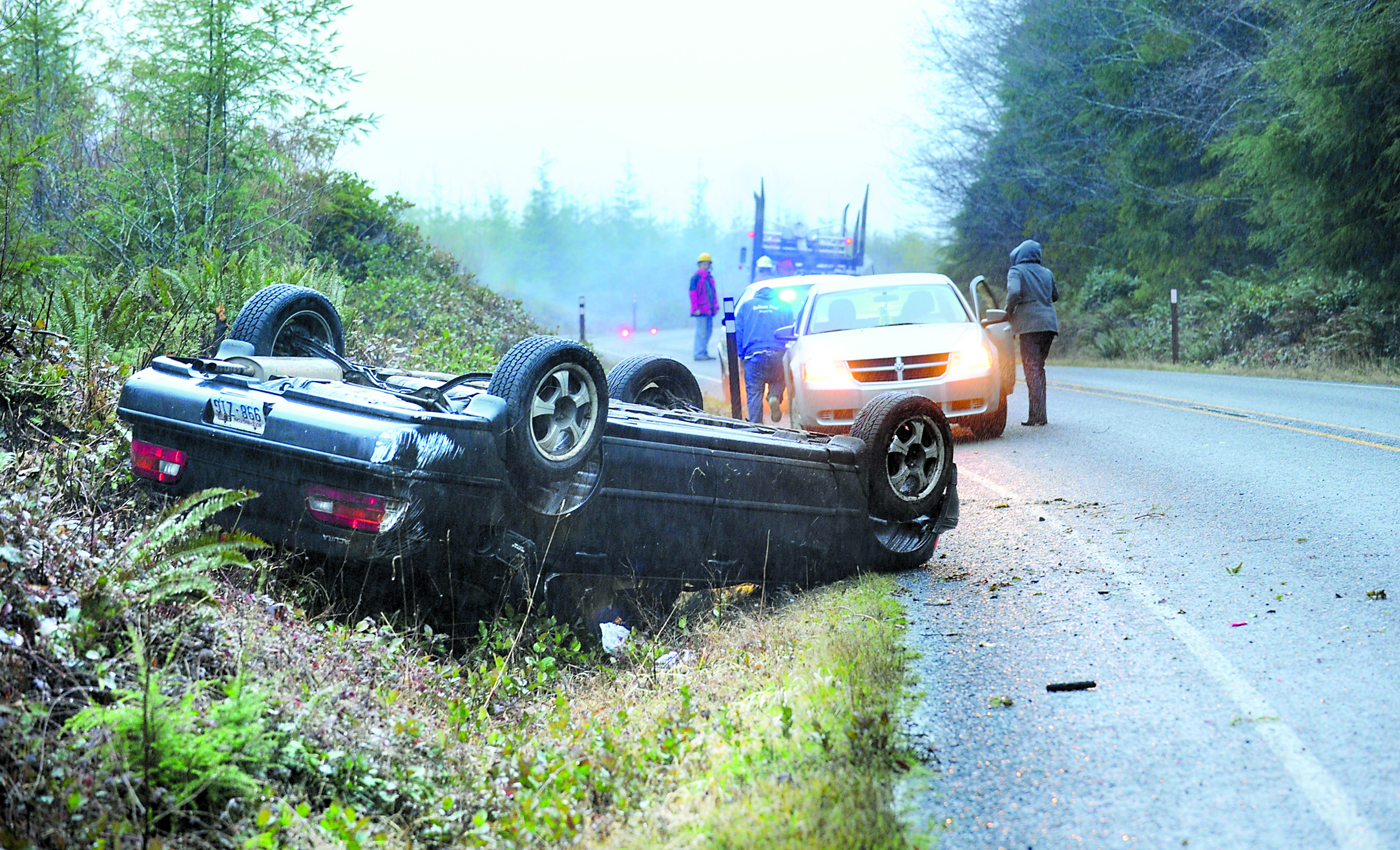 A Clallam County sheriff's deputy and State Patrol trooper respond to a one-car rollover wreck on state Highway 110 west of Forks. Lonnie Archibald/for Peninsula Daily News