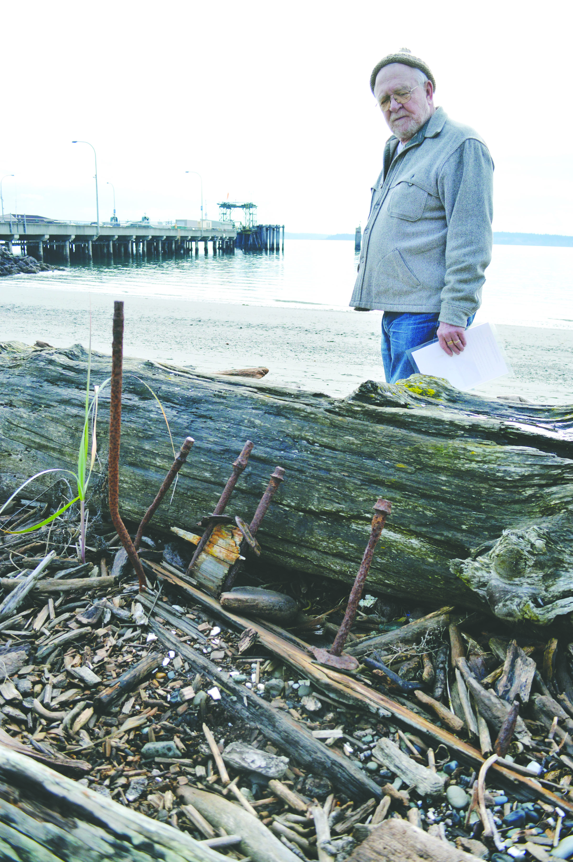 Bernie Arthur looks over a rusting piece of a ship near the beach in downtown Port Townsend he is donating for a memorial to sailors lost at sea. Joe Smillie/Peninsula Daily News