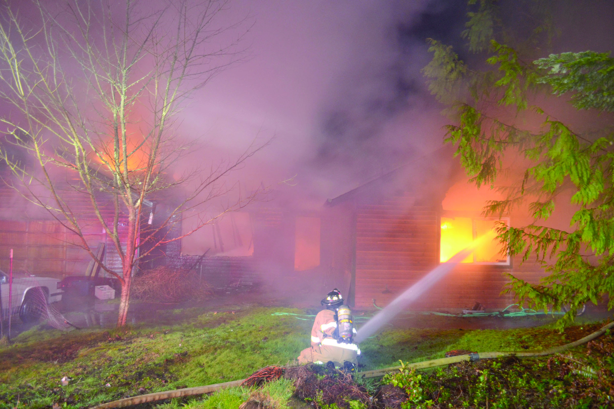 A firefighter battles a blaze on Holcomb Street in Port Townsend early Monday morning. — Bill Beezley/East Jefferson Fire-Rescue