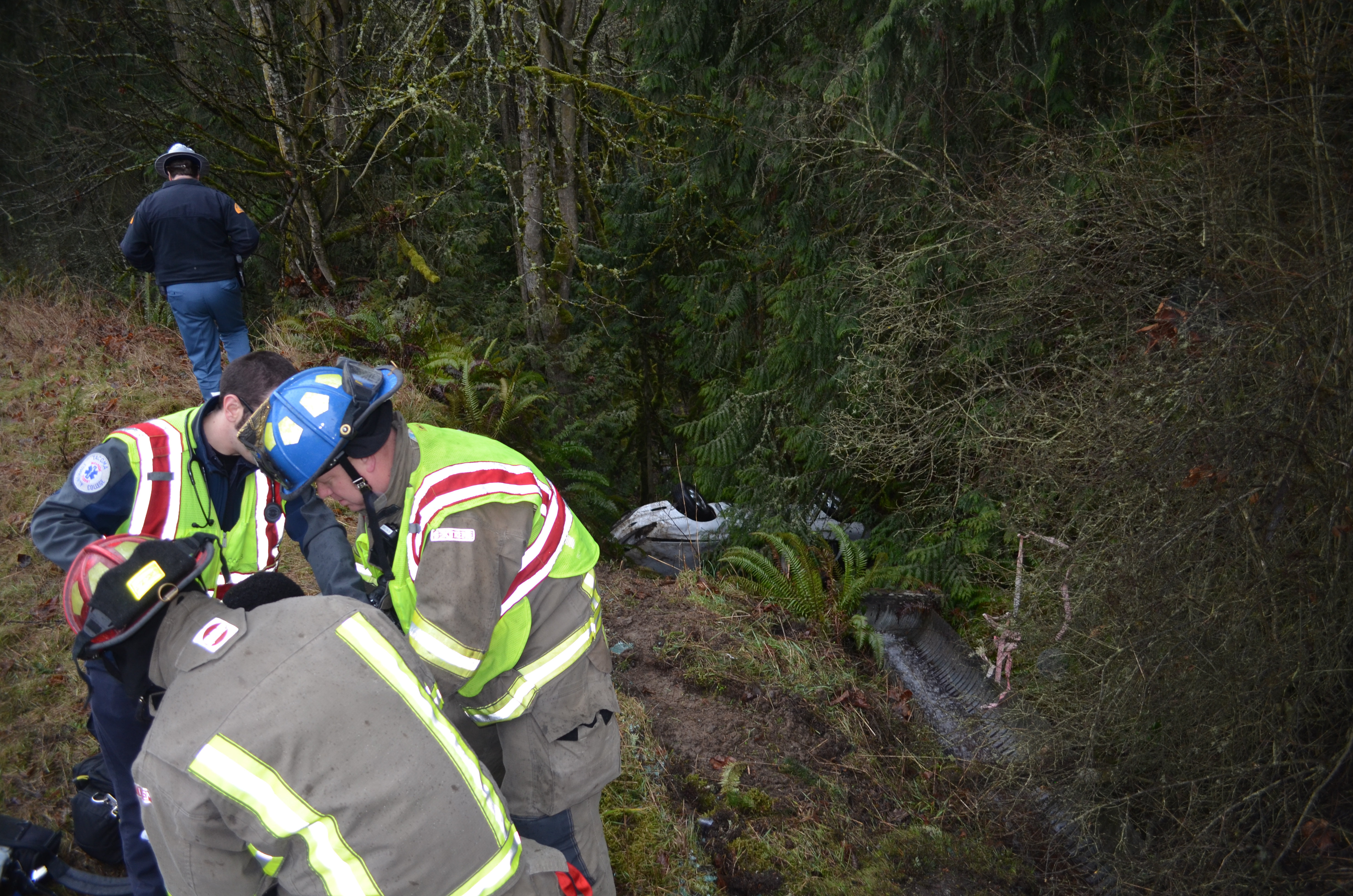 Emergency responders treat a male patient that was in this vehicle when it left U.S. Highway 101 at Whitefeather Way in Sequim on Monday. Patrick Young/Clallam County Fire District No. 3