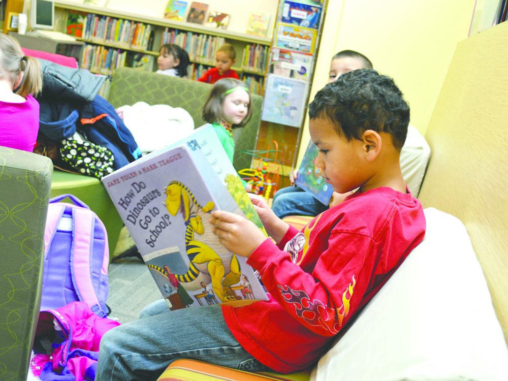 Legend Liggons reads a book in the Sequim Library with classmates on a field trip from Bibity Bobity Child Care in 2013. With usage at the Sequim branch escalating