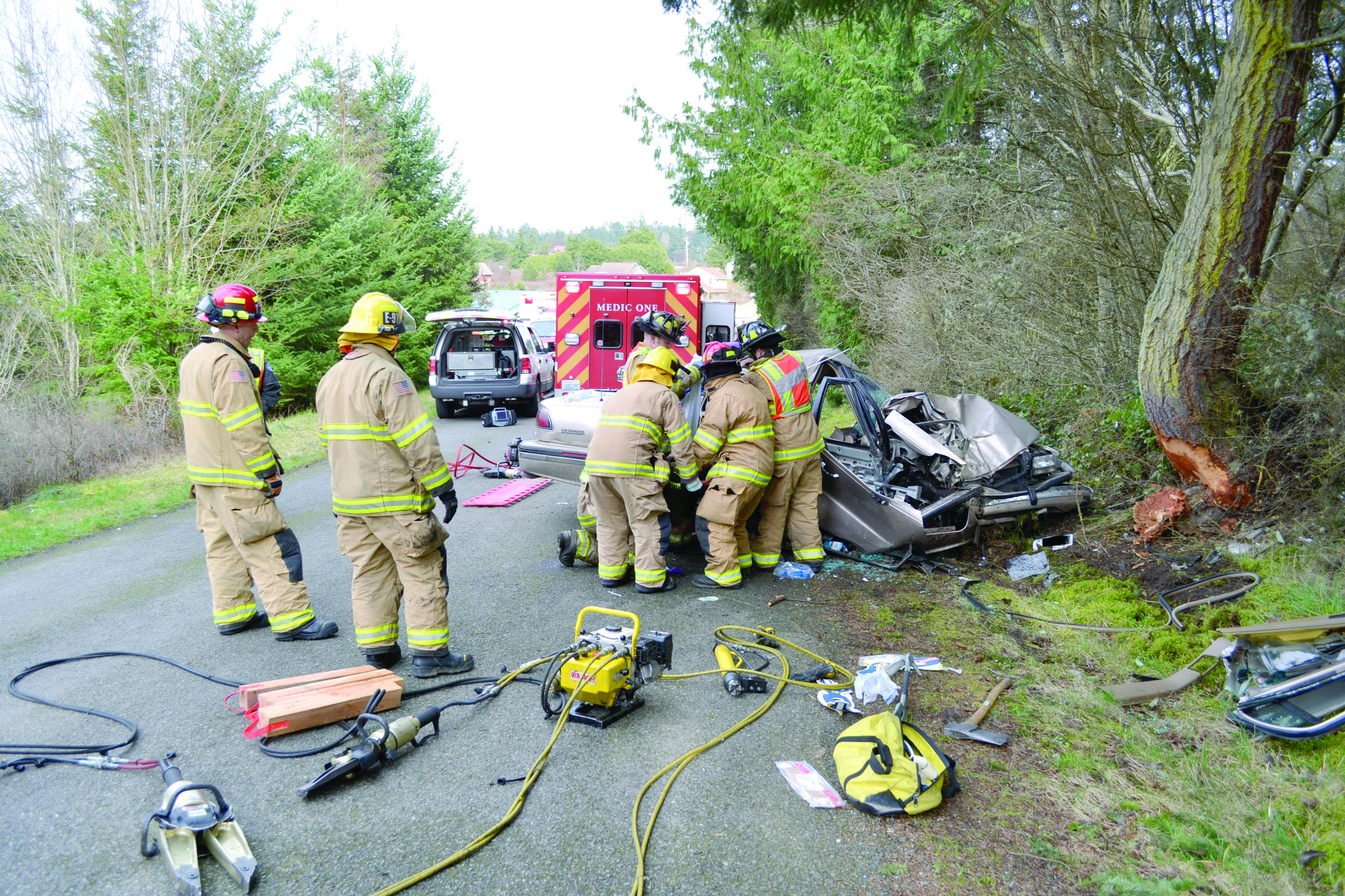 Firefighters use the hydraulic Jaws of Life to remove two people from a car that crashed into a tree in Port Townsend. — Bill Beezley/East Jefferson Fire-Rescue