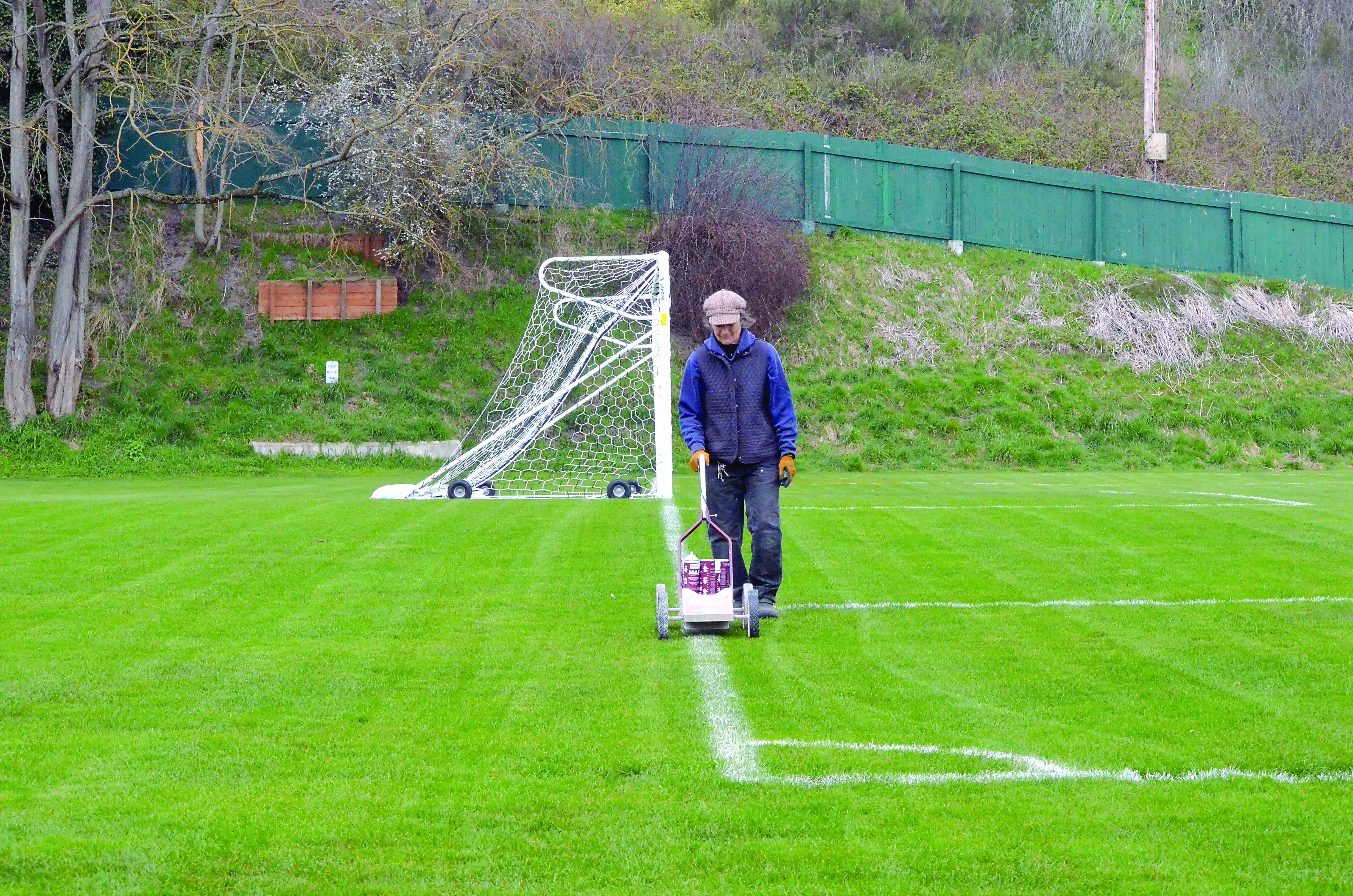 Jefferson County employee Irene Miller paints the lines on Memorial Field in anticipation of a soccer game on Tuesday. The field will be used for the Rhody Fest carnival in May.  —Photo by Charlie Bermant/Peninsula Daily News