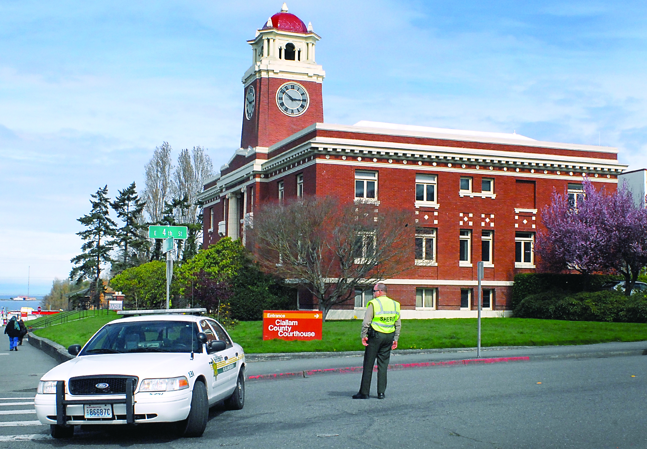 Clallam County Sheriff's Deputy Don Kitchen stands watch at the corner of Fourth and Lincoln streets in Port Angeles after the Clallam County Courthouse was evacuated after a bomb threat on Friday afternoon.  — Photo by Keith Thorpe/Peninsula Daily News