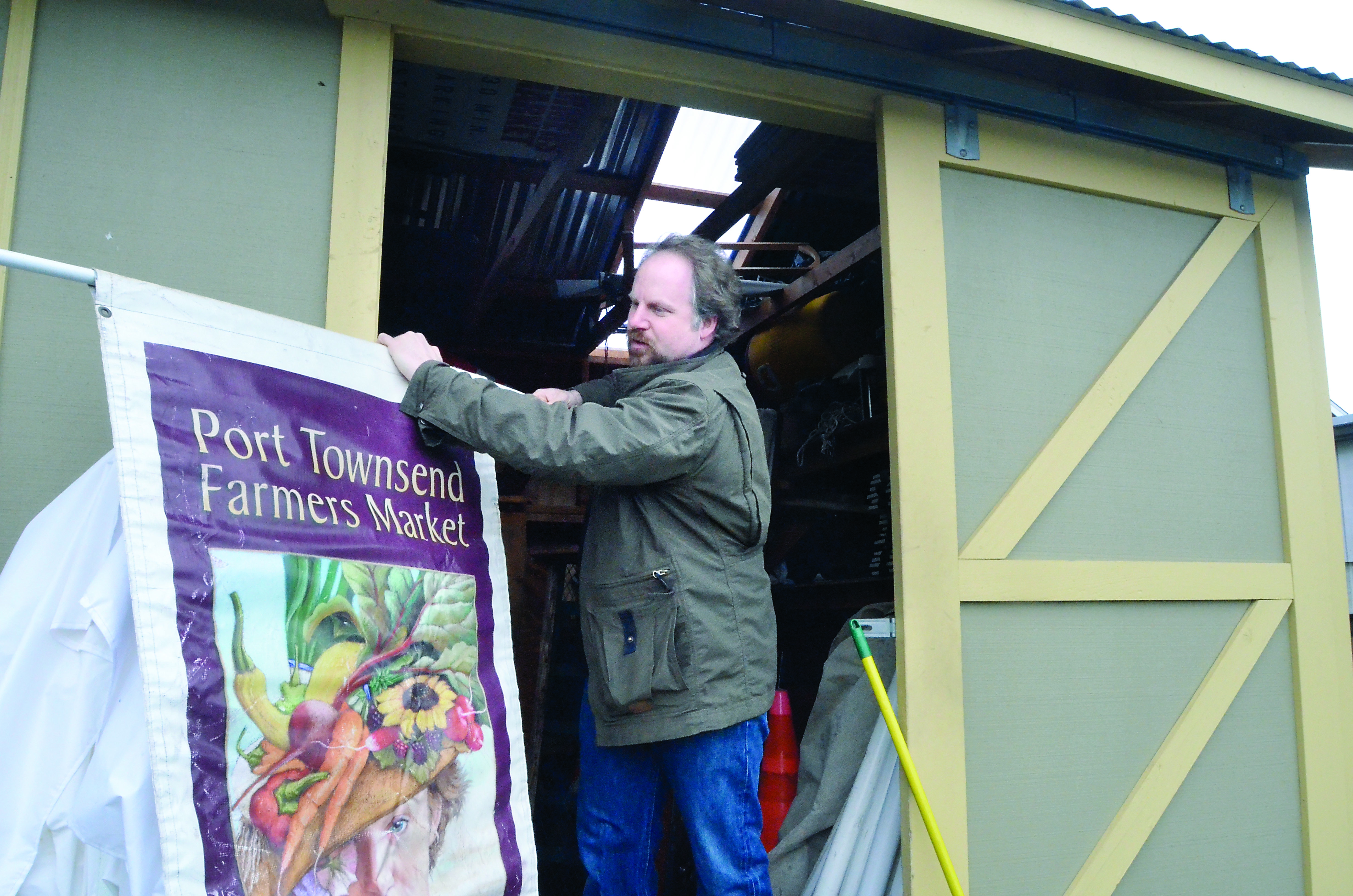 Jefferson County Farmers Market manager Will O'Donnell unloads supplies from the market's storage shed ahead of Saturday's seasonal opening. — Charlie Bermant/Peninsula Daily News