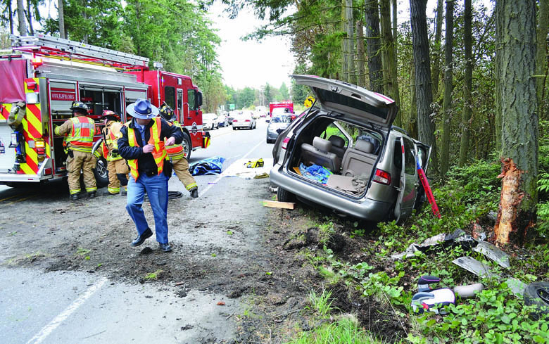 Crews work at the scene where a gold Toyota Sienna minivan crashed off the side of state Highway 20 south of Port Townsend on Saturday. East Jefferson Fire-Rescue