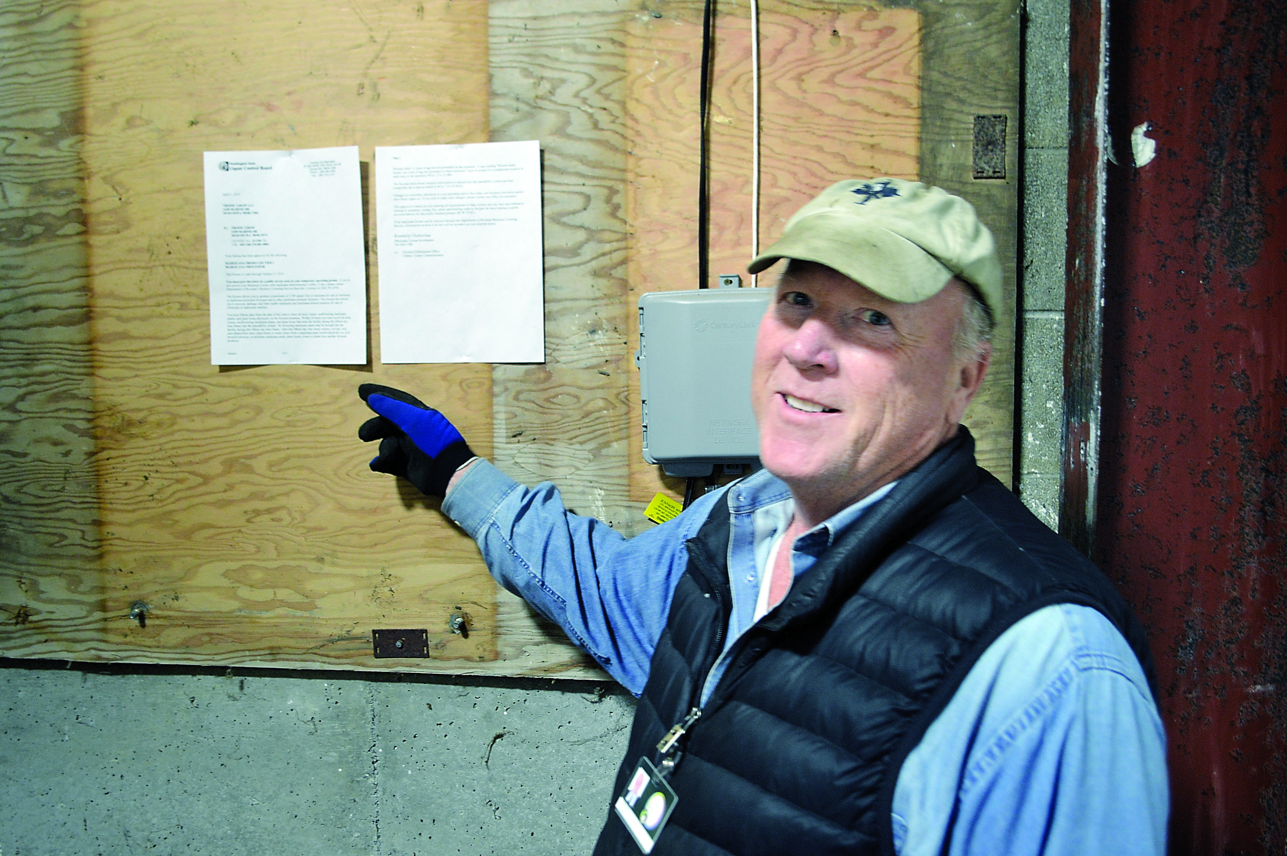 Thomas Ash displays the state-issued license he received April 1 to begin growing the first legal recreational marijuana on the North Olympic Peninsula inside an old dairy barn at Dungeness. — Joe Smillie/Peninsula Daily News