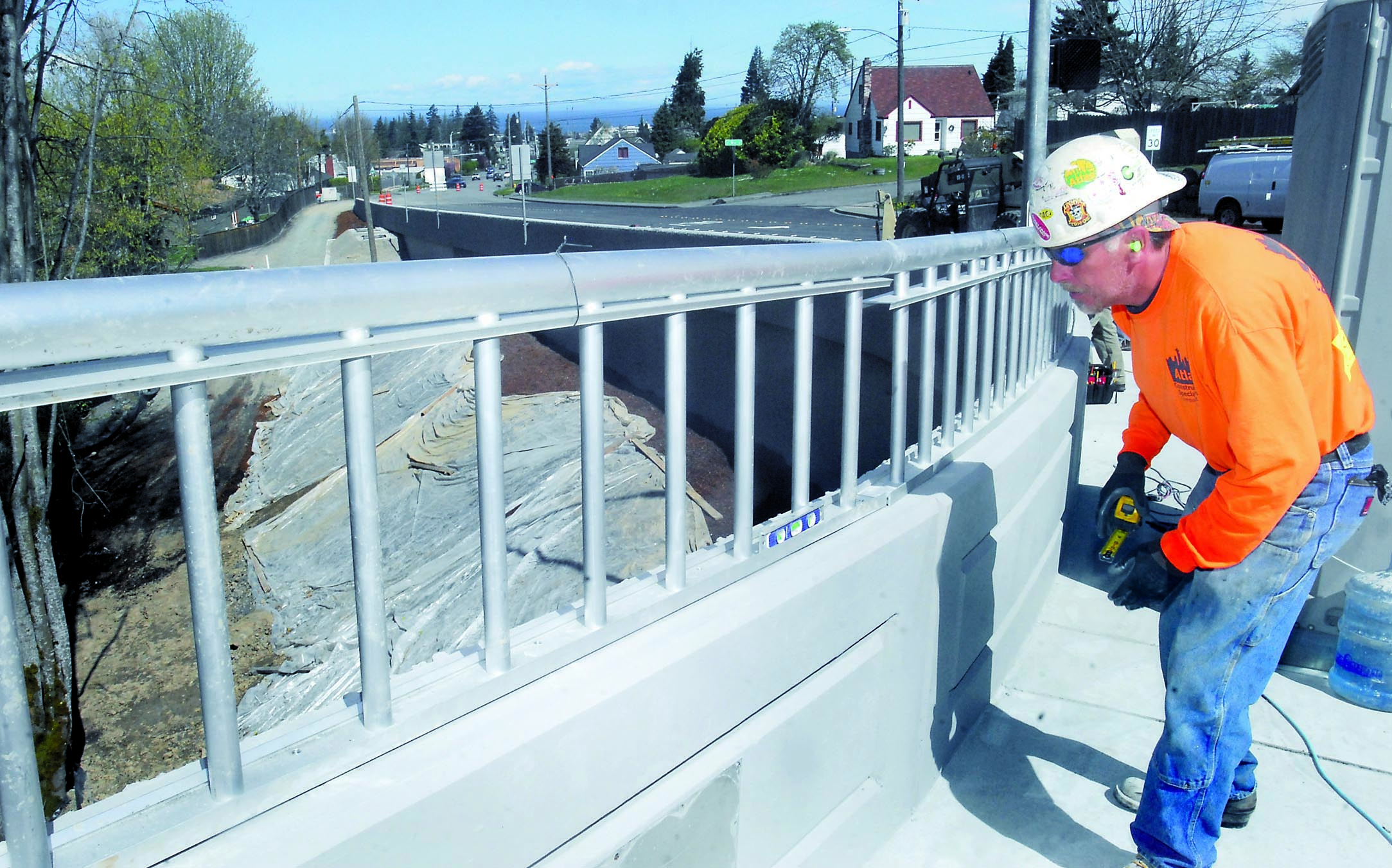 Alan Lubich of Seattle-based SB Structures checks the level on a guardrail of the new Lauridsen Boulevard bridge in Port Angeles. — Keith Thorpe/Peninsula Daily News