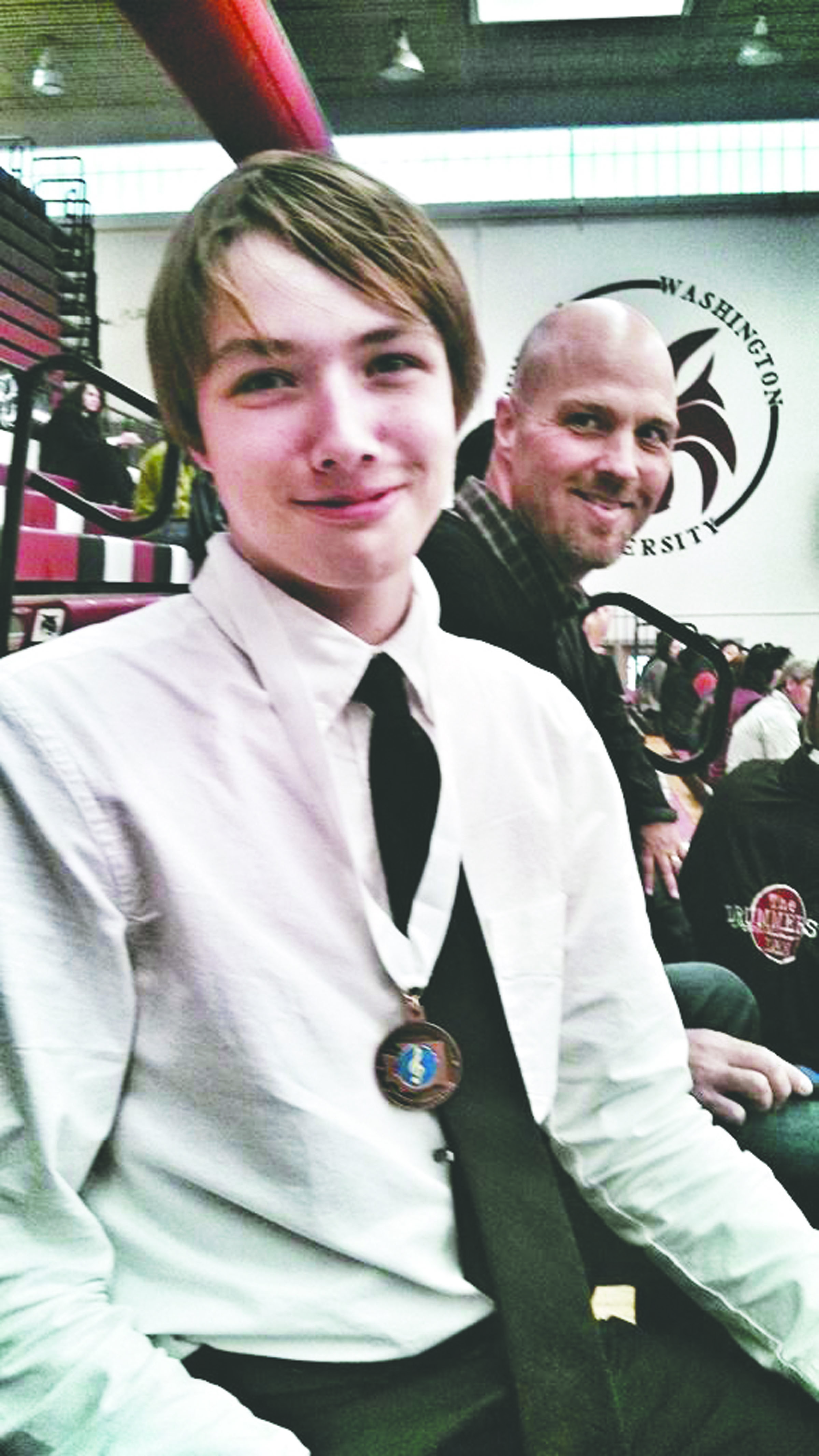 Wearing his third-place medal and with his father