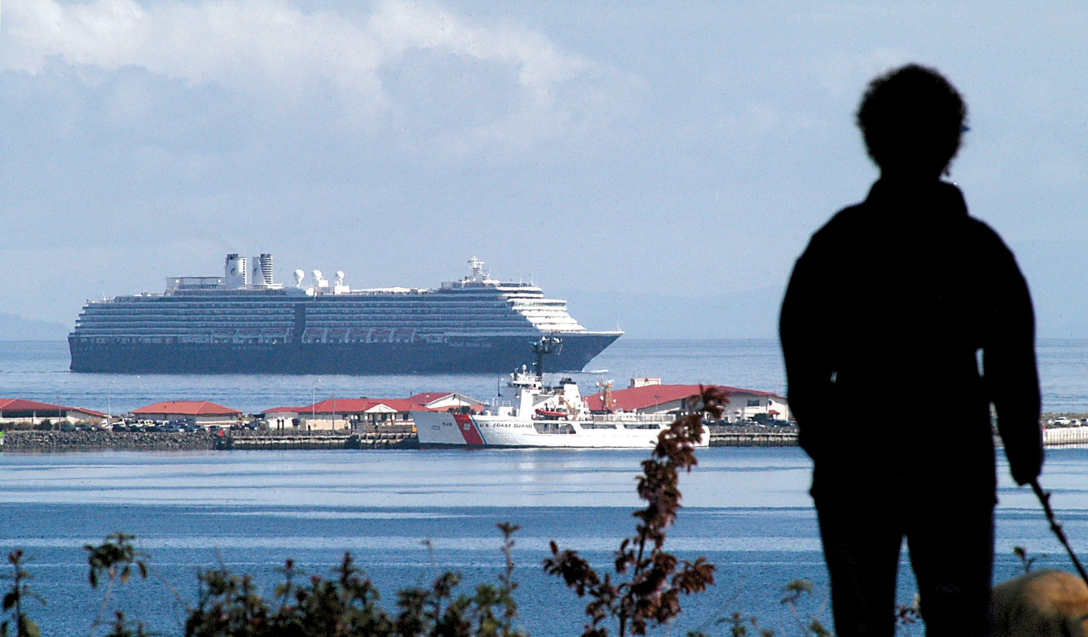 Sherry Ewing of Port Angeles looks from the bluff above downtown Port Angeles as the cruise ship Oosterdam arrives for port of call in Port Angeles in