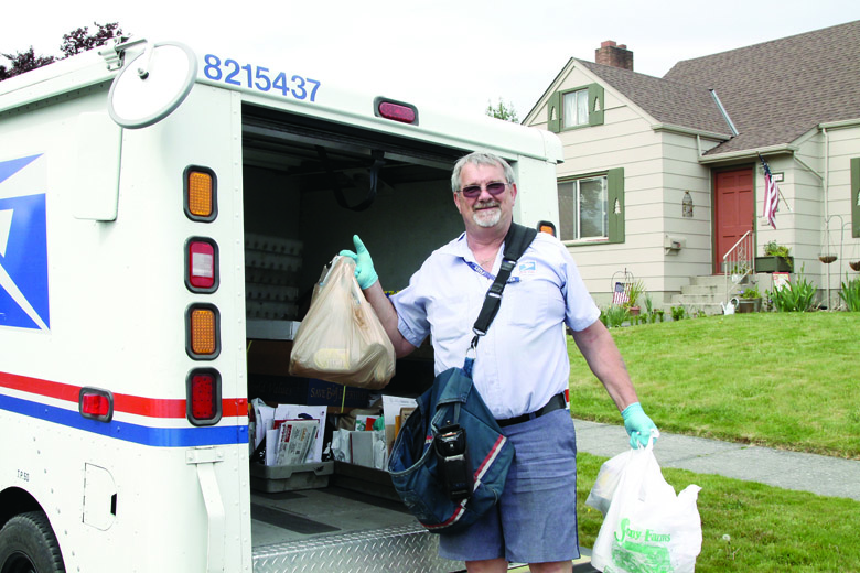 Postal carrier Don Sargent collects donations on Oak Street for the Stamp Out Hunger food drive in 2013. Dave Logan/for Peninsula Daily News