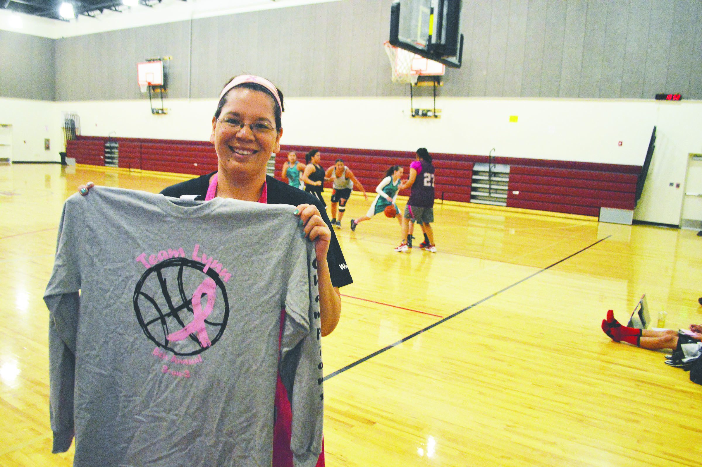 Sharon Kanichy shows off the victory shirt awarded to winners at the fifth annual Team Lynn 3-on-3 basketball tournament held in honor of Kanichy’s mother