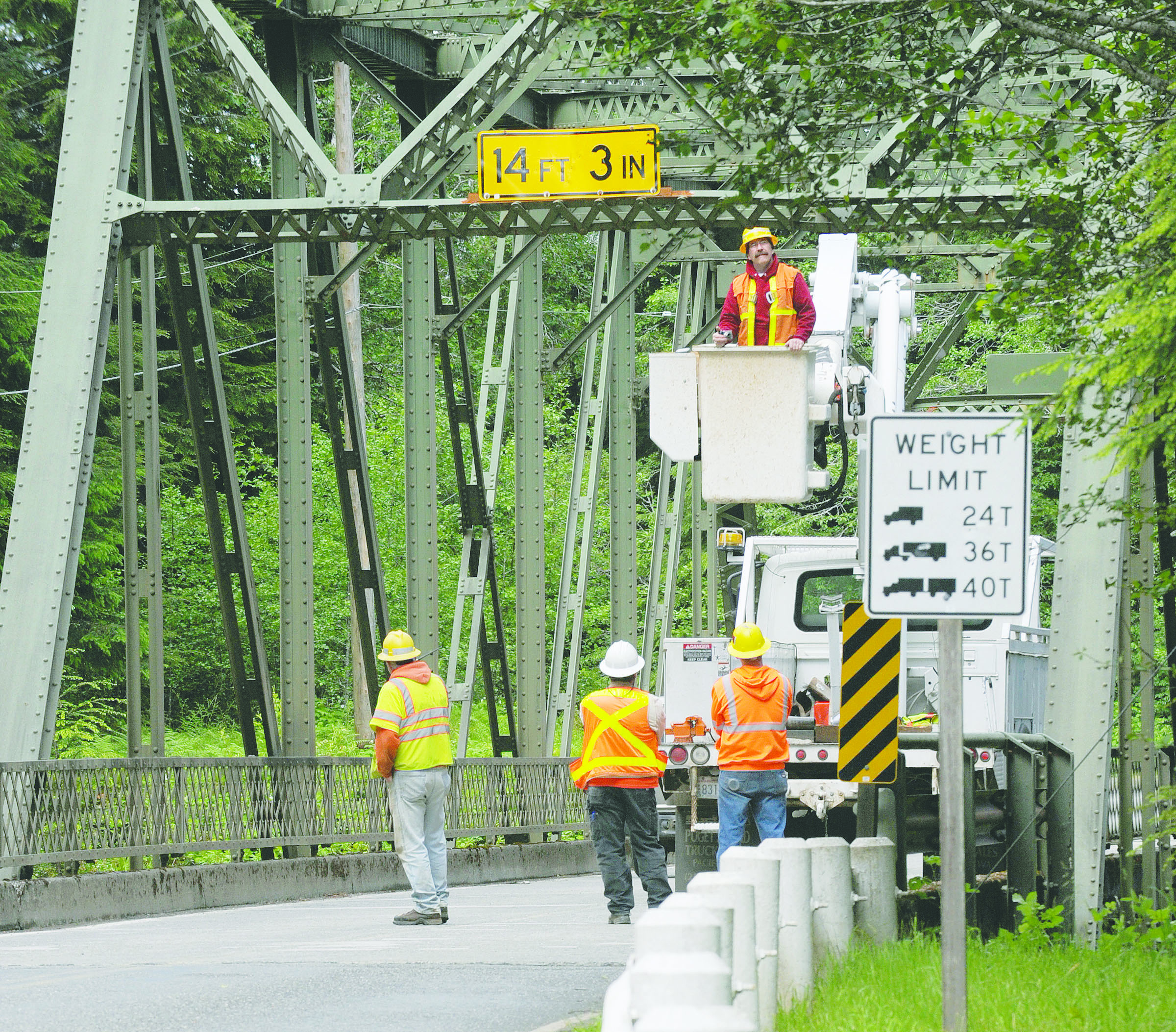 Clallam County road crews last year inspect the aged steel-truss bridge that carries Quillayute Road over the Sol Duc River about 4 miles west of Forks. A truck had just hit one of the overhead components of the bridge.  -- Photo by Lonnie Archibald/for Peninsula Daily News