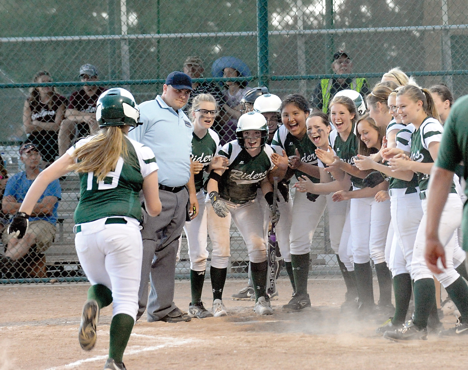 Port Angeles' Alicia Howell (19) trots home as her teammates gather to congratulate her after she hit a three-run home run against Colville. Lonnie Archibald/for Peninsula Daily News