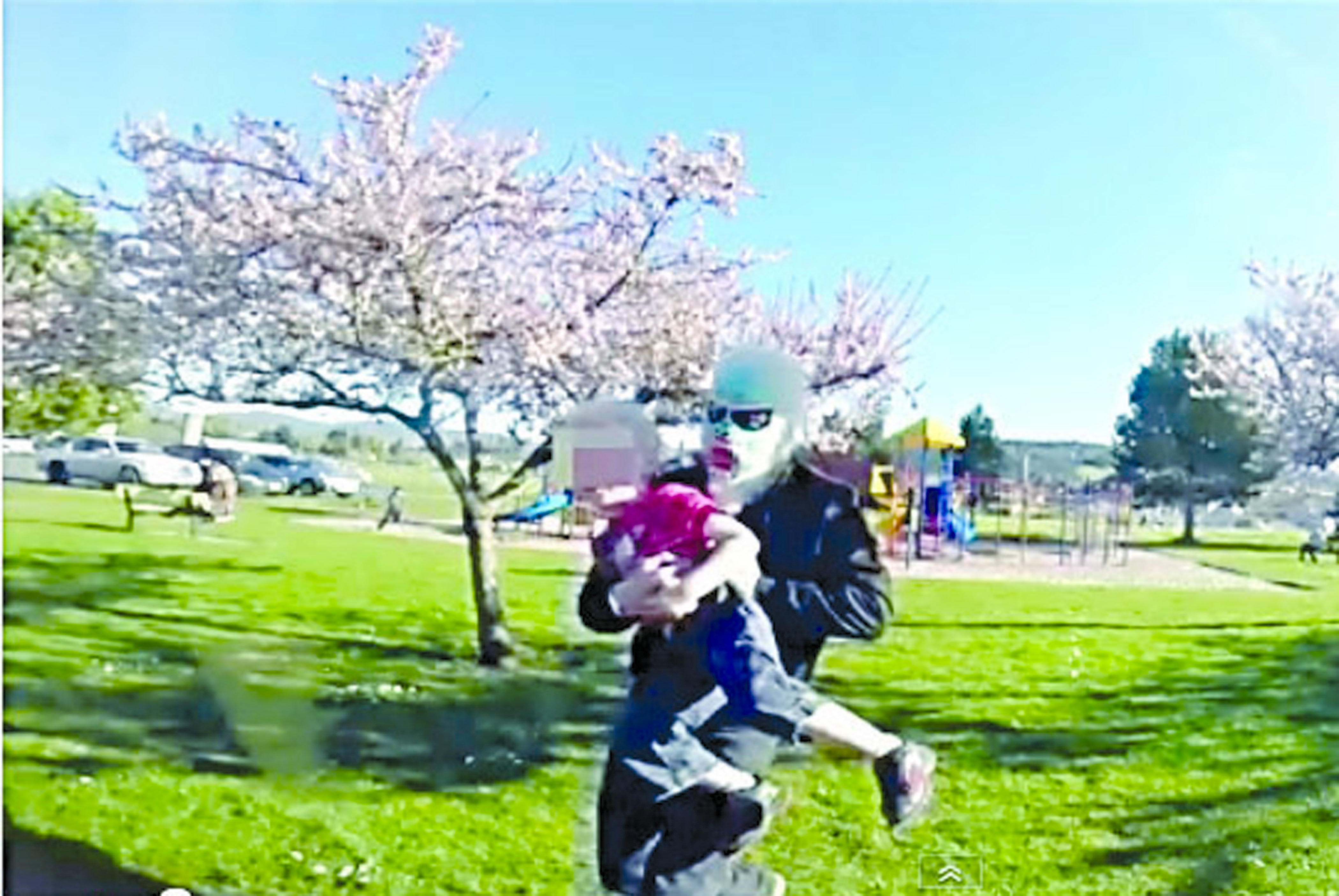 A masked figure is shown carrying a 4-year-old child across Carrie Blake Park in Sequim in this scene from a YouTube video two brothers made April 13.