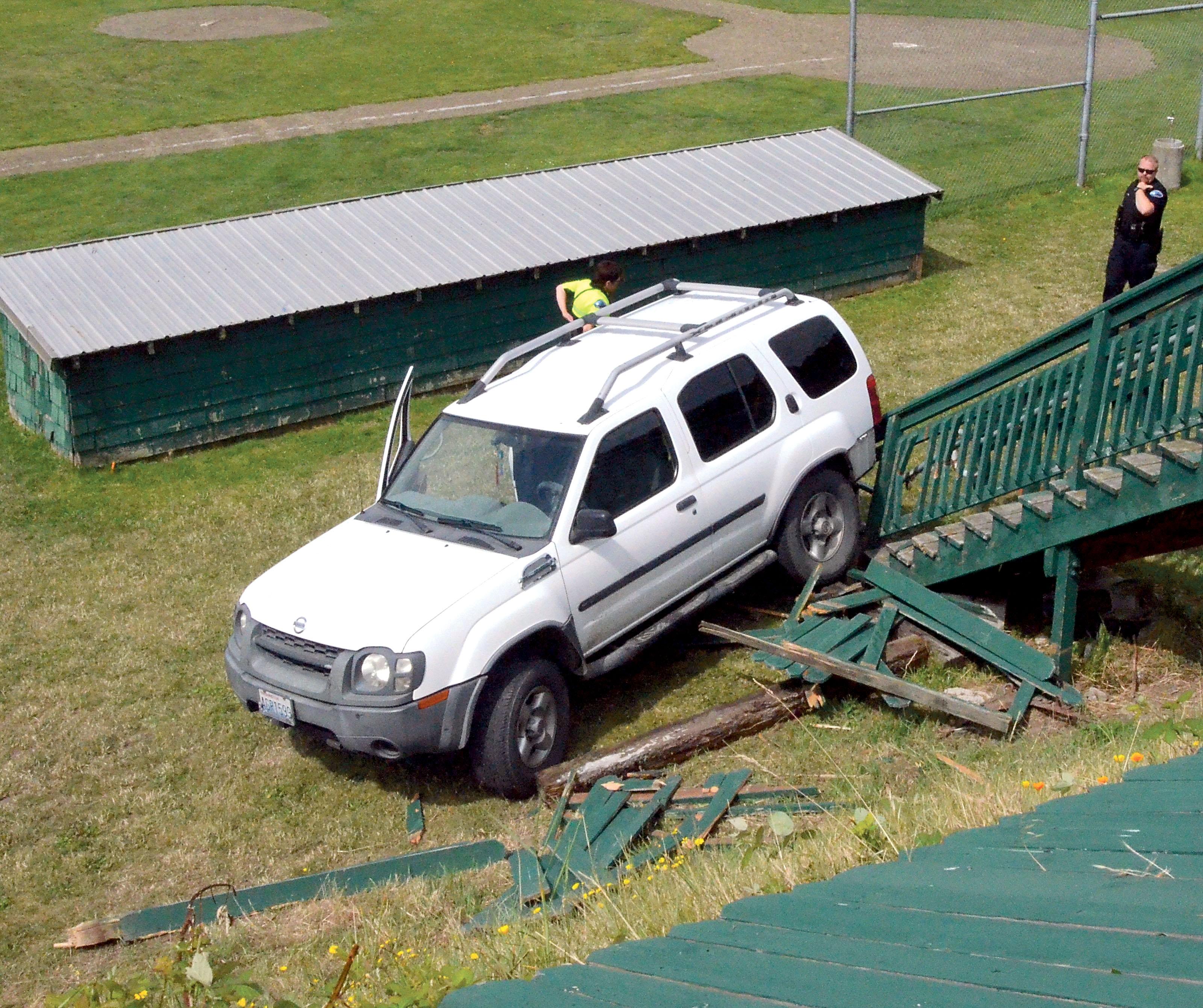 This 2003 Nissan Xterra rests against a damaged staircase at Memorial Field in Port Townsend after backing through a fence and rolling down an embankment onto the athletic field. Charlie Bermant/Peninsula Daily News