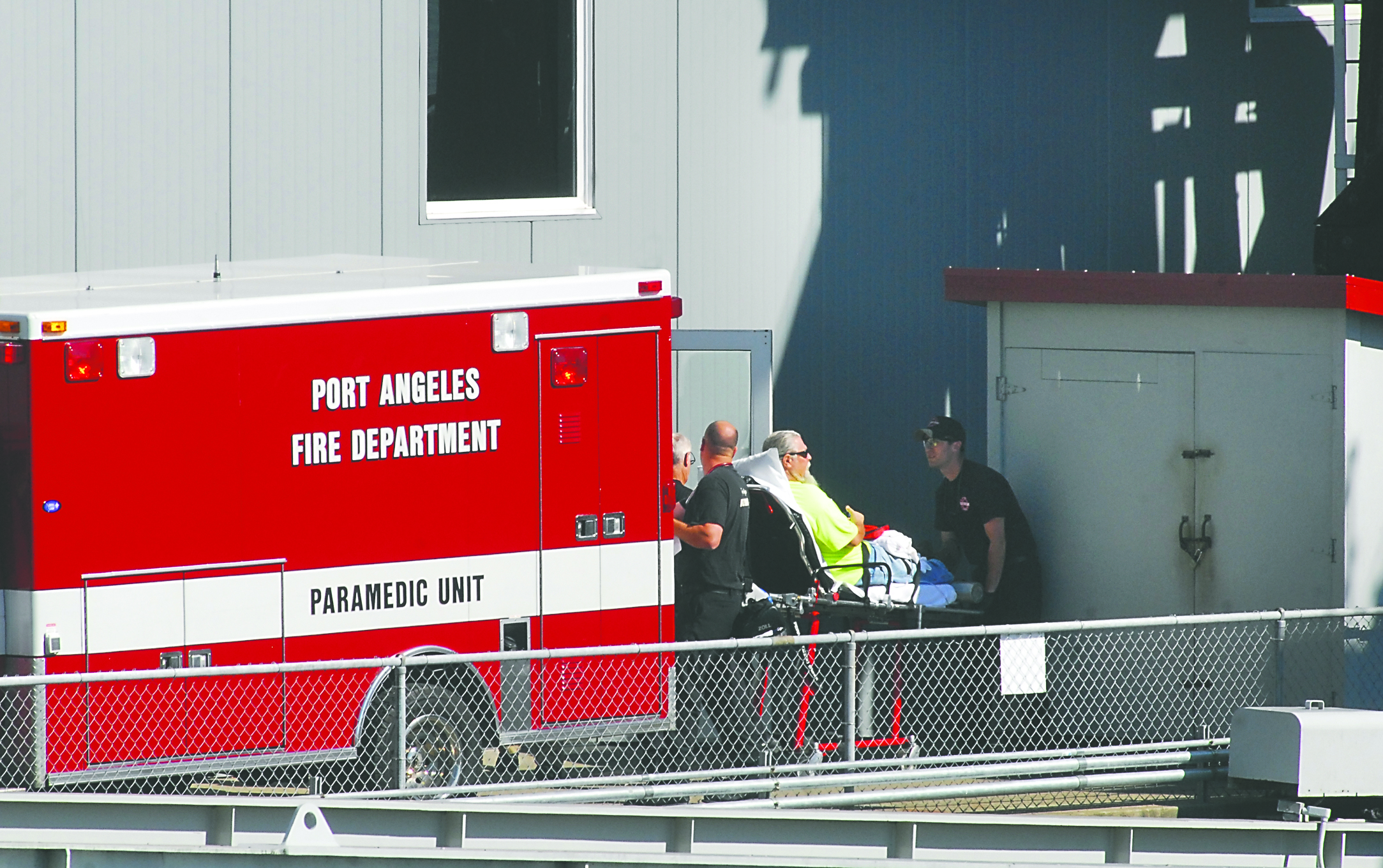 Port Angeles city rescue workers take a patient to the rear of a waiting ambulance at the Black Ball Ferry dock in after the MV Coho returned to Port Angeles part way through its morning run to Victoria.  -- Photo by Keith Thorpe/Peninsula Daily News