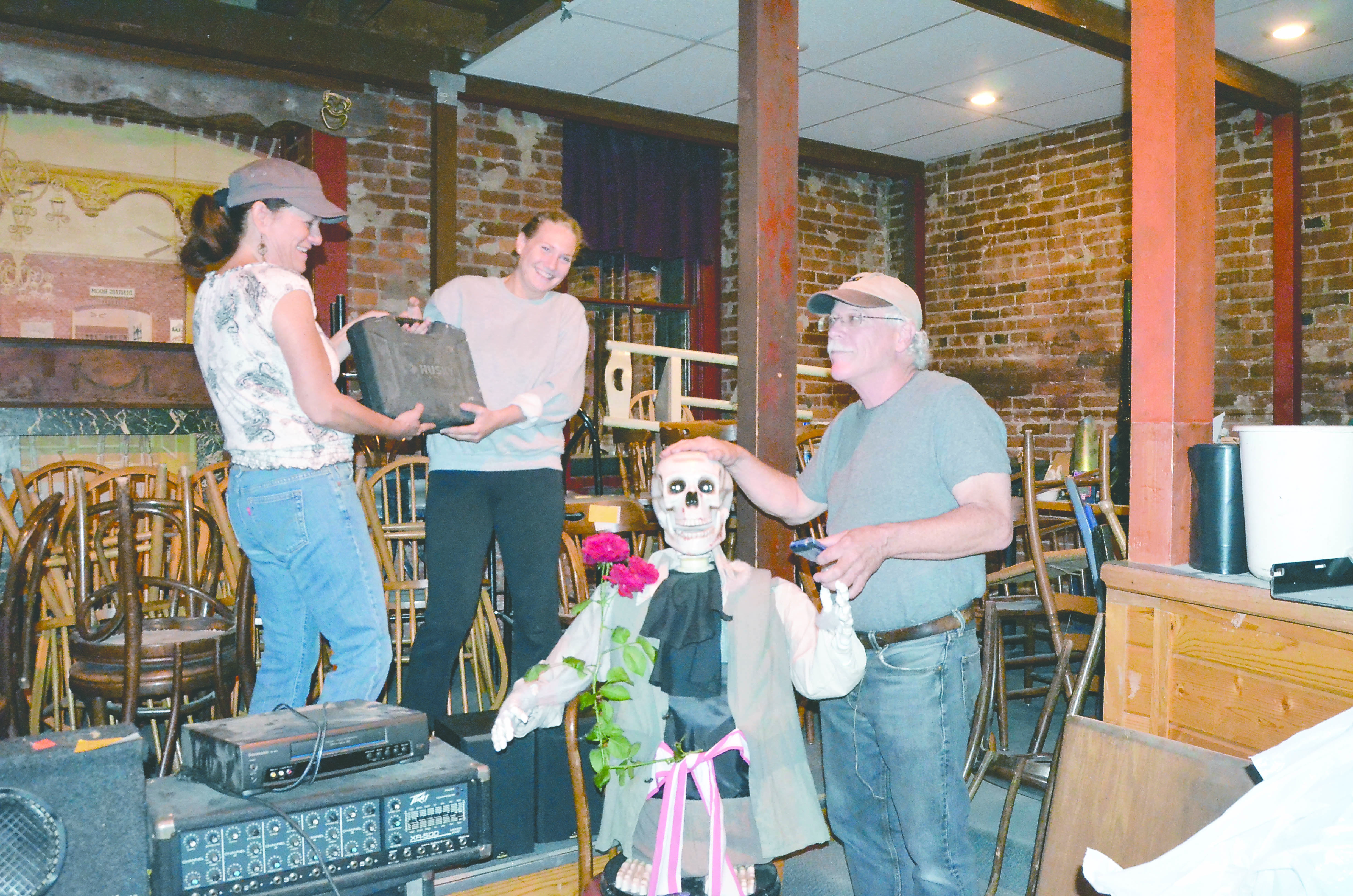 Upstage owner Mark Cole prepares a skeleton doll for a weekend sale that will support opening the club in a new location while his girlfriend