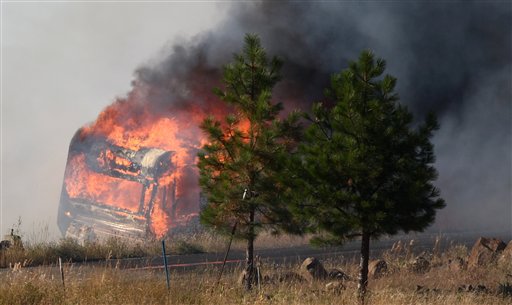 A trailer erupts in flames at the Sunlight Waters housing development as the Taylor Bridge wildfire advances on the community near Cle Elum.  -- The Associated Press photo