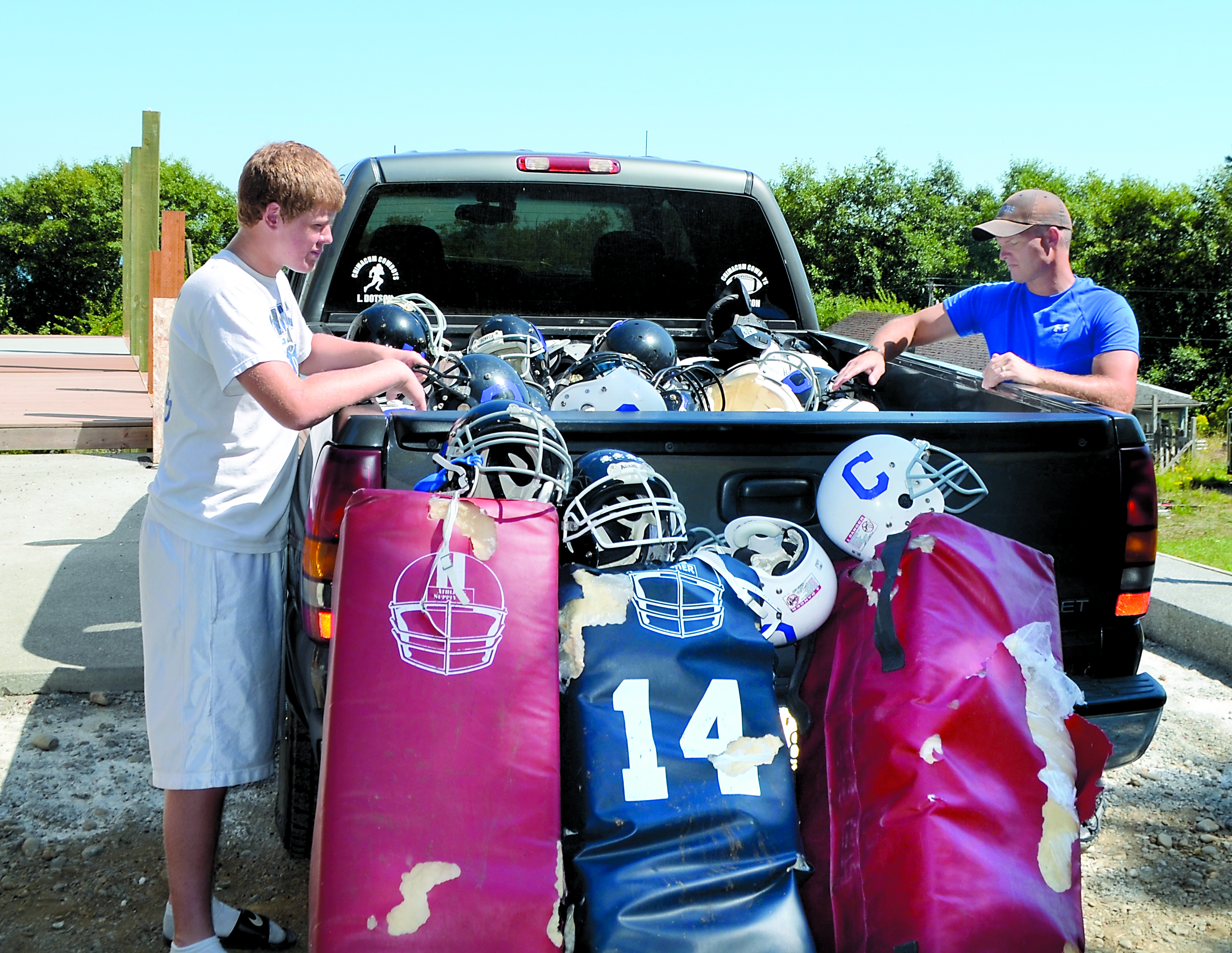 Lane Dotson and Darrin Dotson sort the helmets