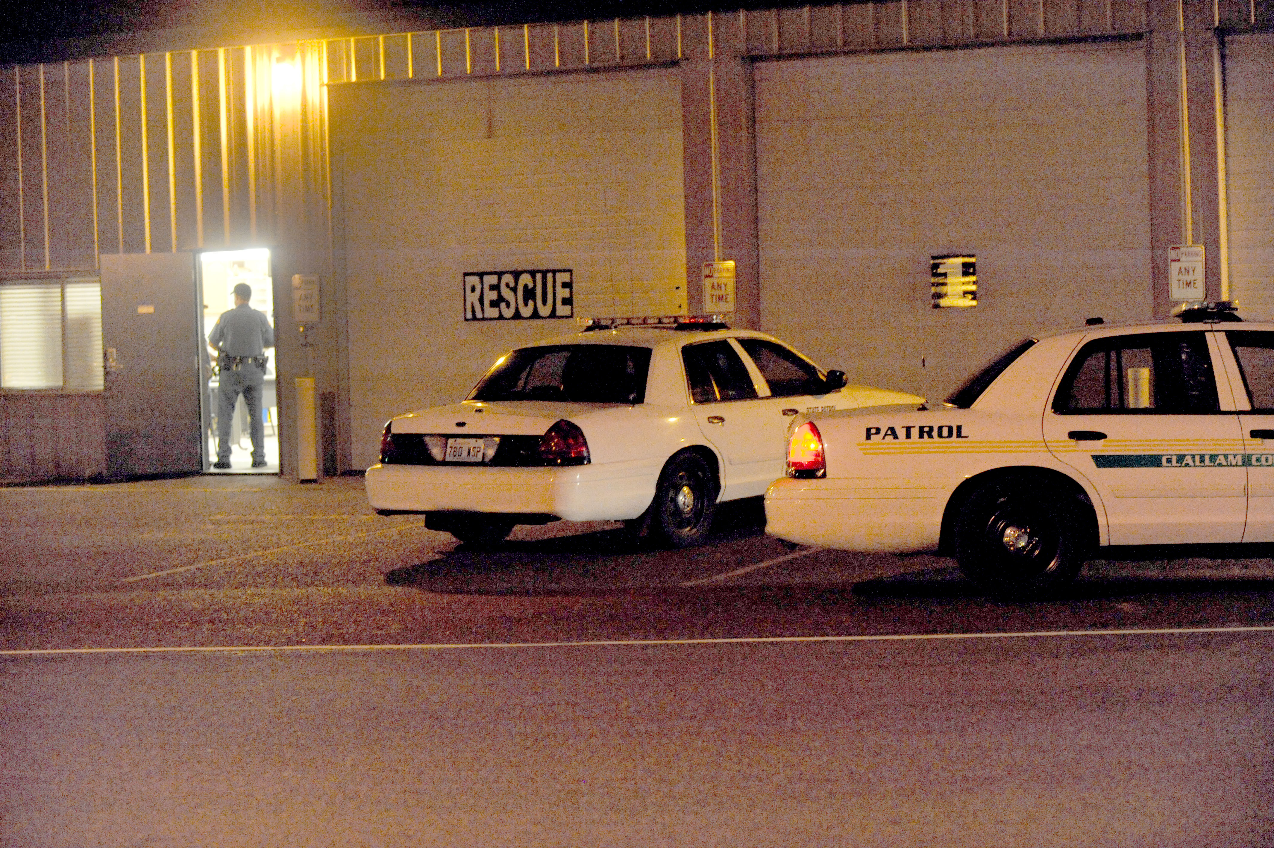 A State Patrol trooper stands in the doorway of the Forks Ambulance headquarters where law enforcement representing Forks Police