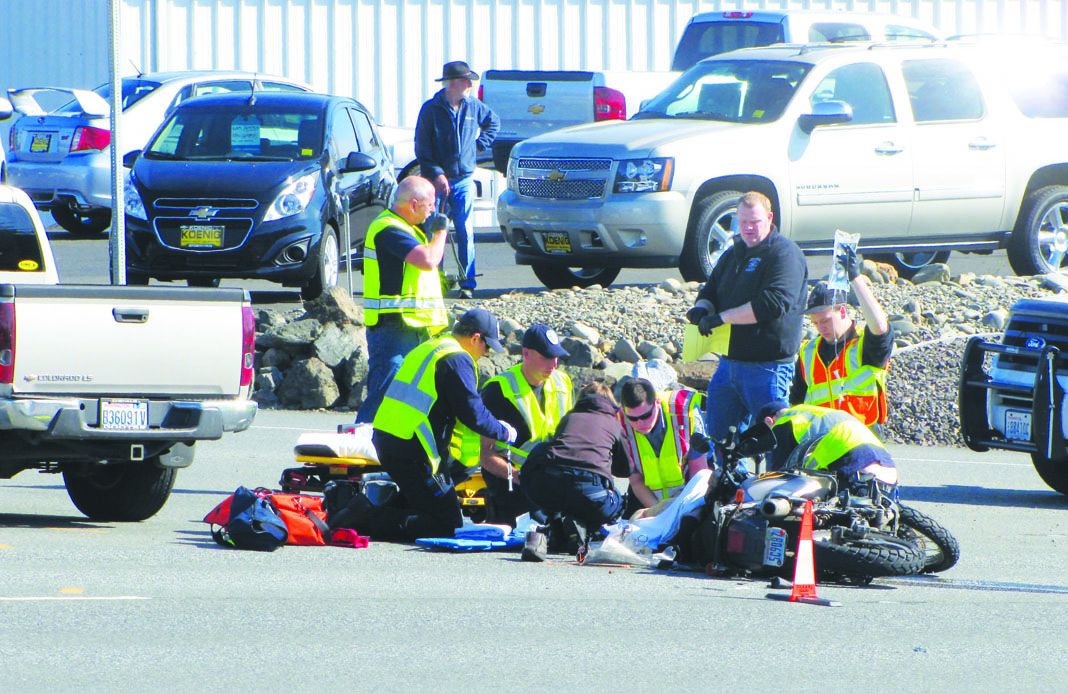 Emergency workers tend to David C. Mills on Sunday morning in the westbound right lane of U.S. Highway 101 in Port Angeles. Arwyn Rice/Peninsula Daily News