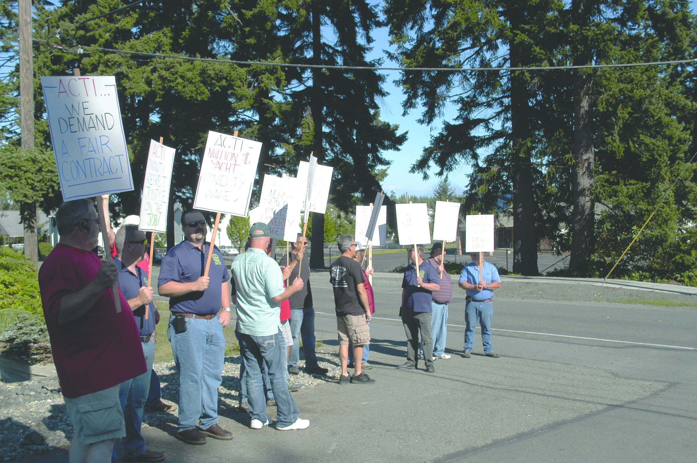 Pickets hold signs outside the Angeles Composite Technologies Inc. plant in west Port Angeles on Monday.  -- Photo by Rob Ollikainen/Peninsula Daily News