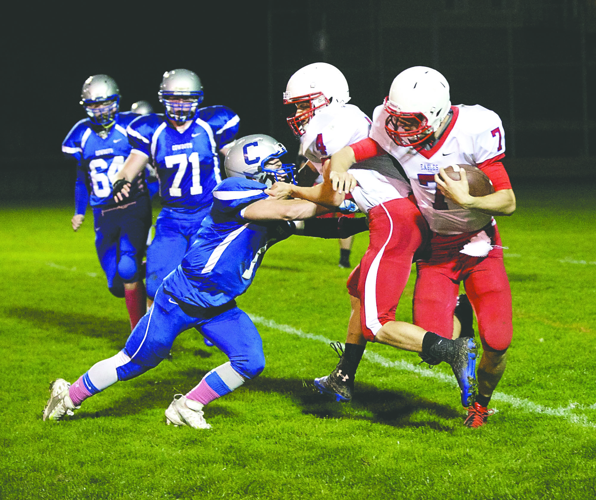 Chimacum's Drew Yackulic (1) uses Life Christian Academy's Hunter Haley (4) to take down Taylor Roelofs (7) during Chimacum's homecoming game at Memorial Field. Steve Mullensky/for Peninsula Daily News