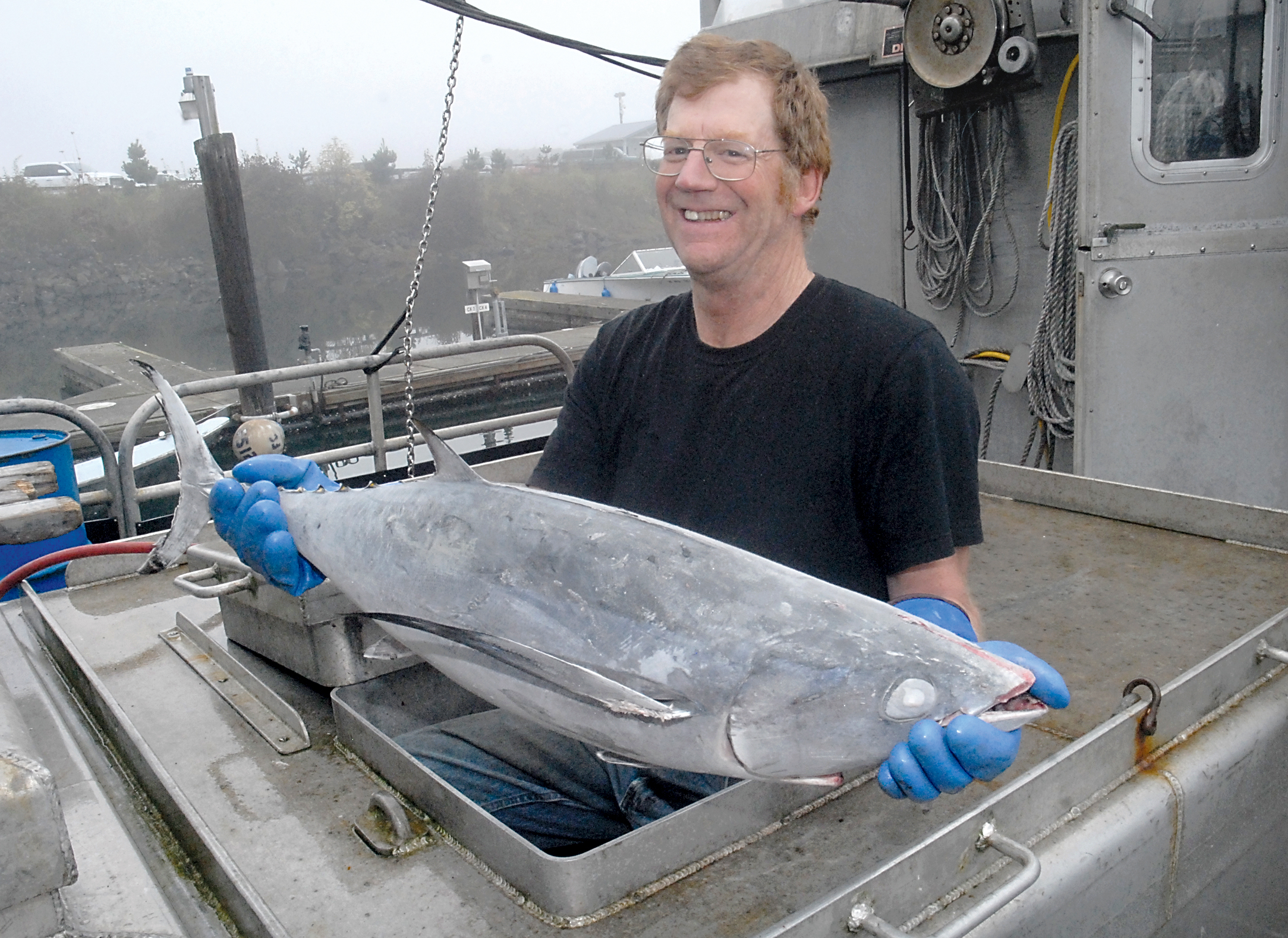 Allan Richardson of Dungeness Seaworks displays a frozen albacore tuna pulled from the hold of his boat