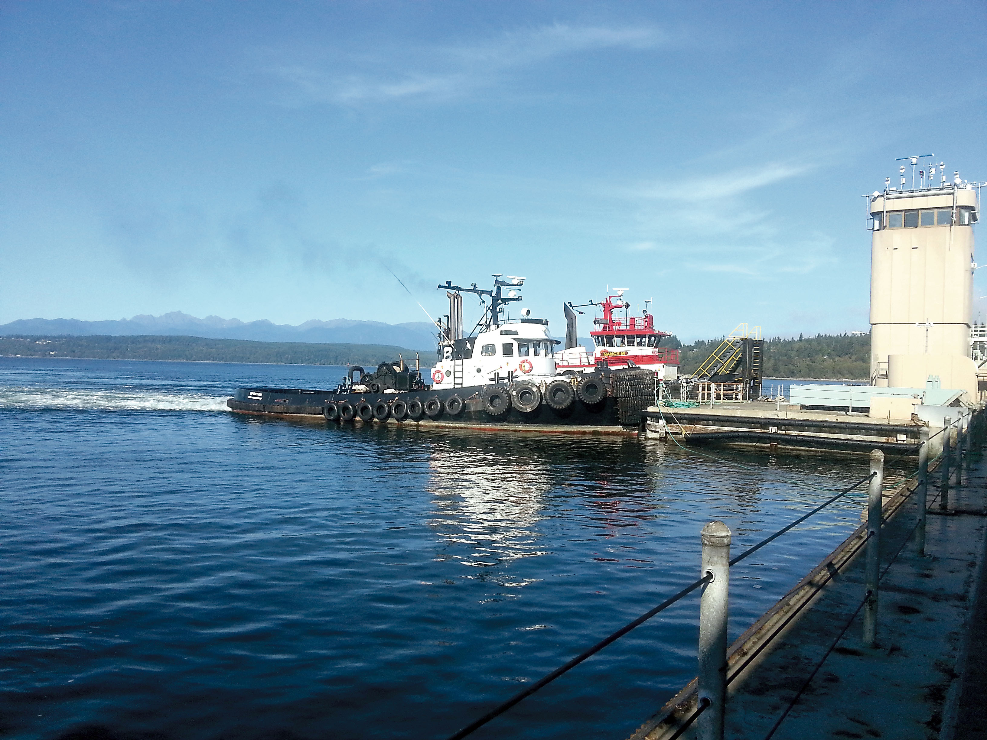 Two tugs push on the platform that holds the control tower at the Hood Canal Bridge to exert pressure on the drawspan and keep it in alignment with the bridge in mid-September. State Department of Transportation