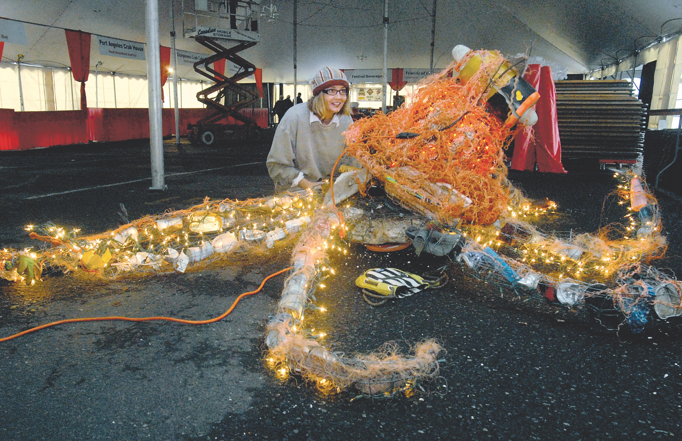 Artist Sarah Tucker makes adjustments to an octopus sculpture made from marine debris before its installation today in the main tent of the Dungeness Crab and Seafood Festival in Port Angeles. Keith Thorpe/Peninsula Daily News