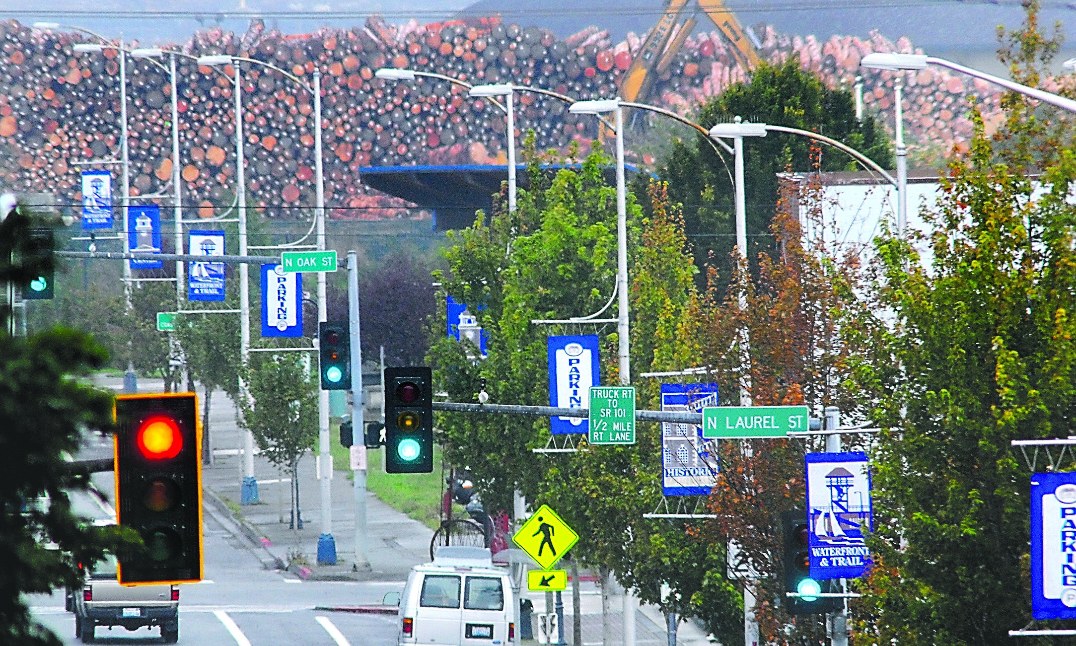 A telephoto lens on Front Street just east of Lincoln Street compresses eight of the light poles eventually to be replaced in downtown Port Angeles. The optical effect makes the log deck west of Valley Creek appear larger.-- Photo by Keith Thorpe/Peninsula Daily News