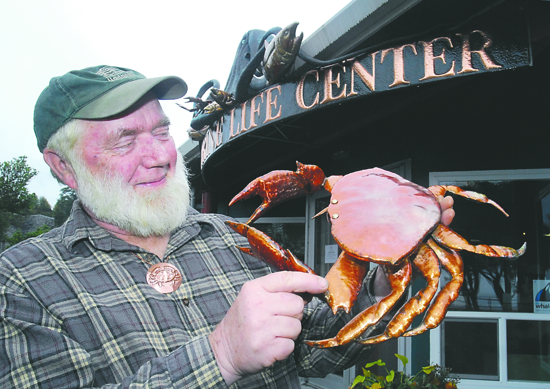 Port Angeles coppersmith Clark Mundy shows off a copper crab sculpture that will be featured at this year's Dungeness Crab & Seafood Festival. Mundy also created the facade of the Feiro Marine Life Center