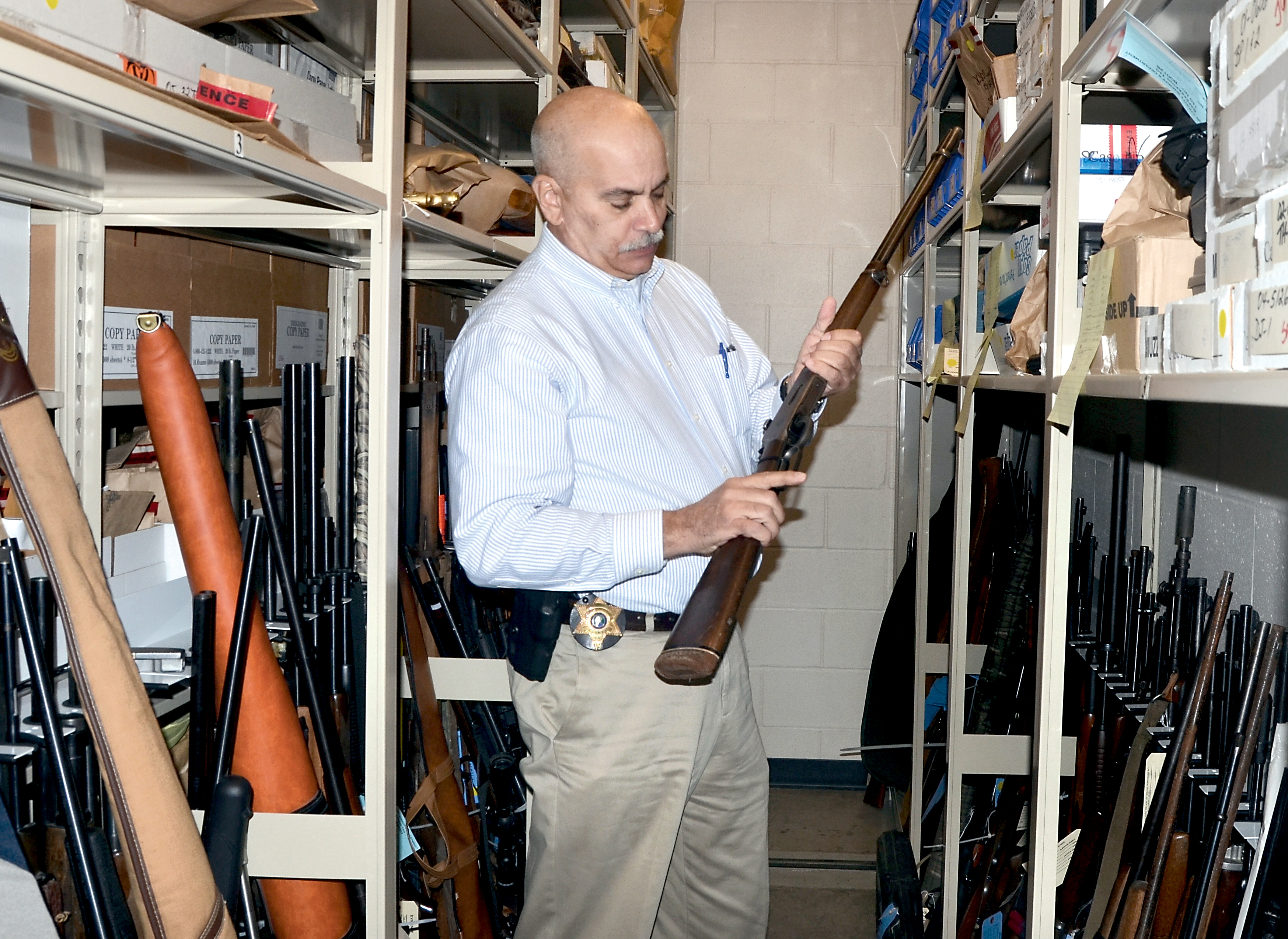 Jefferson County Undersheriff Joe Nole places a gun in the evidence locker at the department's Port Hadlock office. Tighter controls on evidence is one recommendation the department will need to follow in order to earn accreditation. Charlie Bermant/Peninsula Daily News