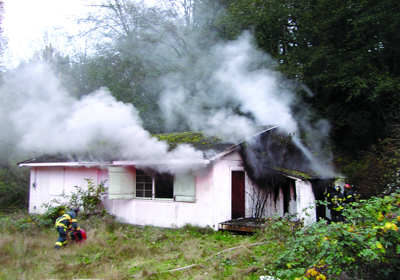 Port Angeles Fire Department firefighters work to extinguish a building fire at 503 S. Valley St. Arwyn Rice/Peninsula Daily News