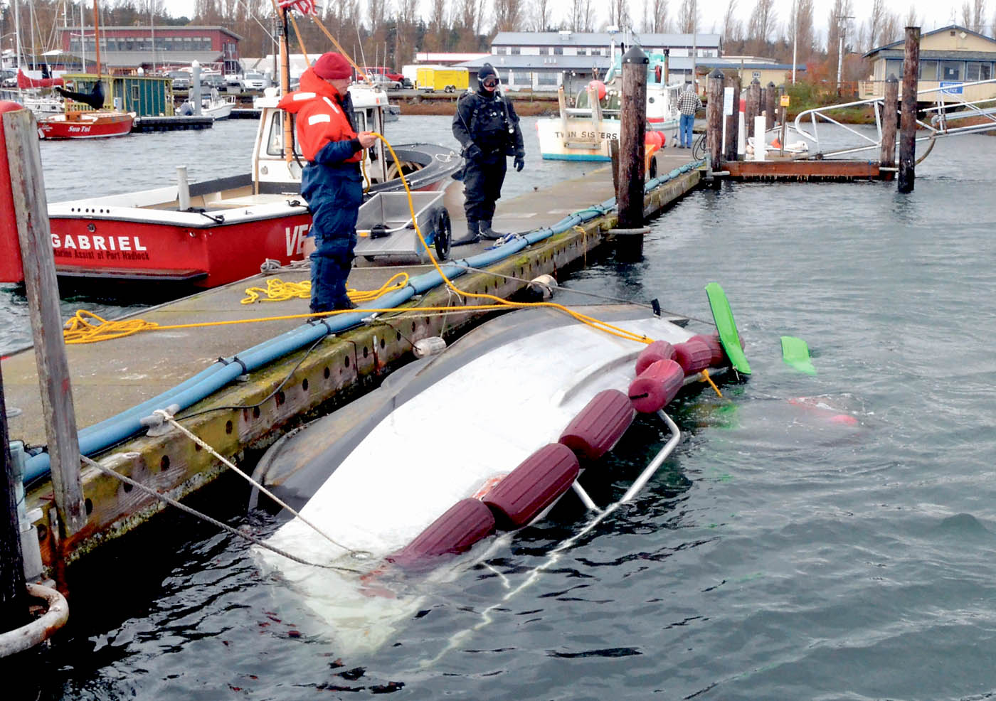 A diver places flotation devices beneath the 21-foot aluminum rescue boat of East Jefferson Fire-Rescue on Thursday.  -- Photo by Charlie Bermant/Peninsula Daily News