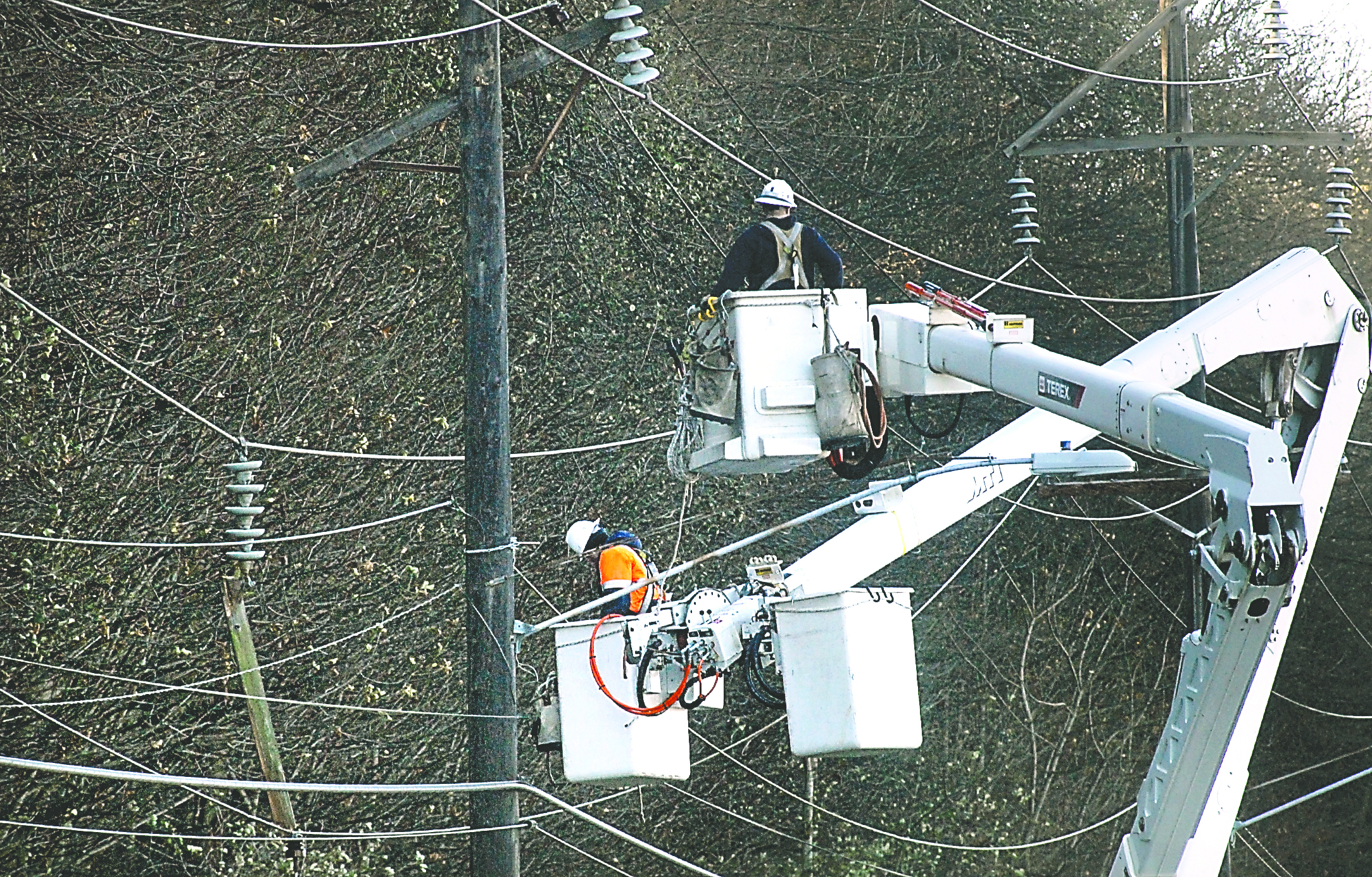 Port Angeles public utility crews work to repair a broken power line support and dangling line on Marine Drive in Port Angeles on Tuesday. Keith Thorpe/Peninsula Daily News