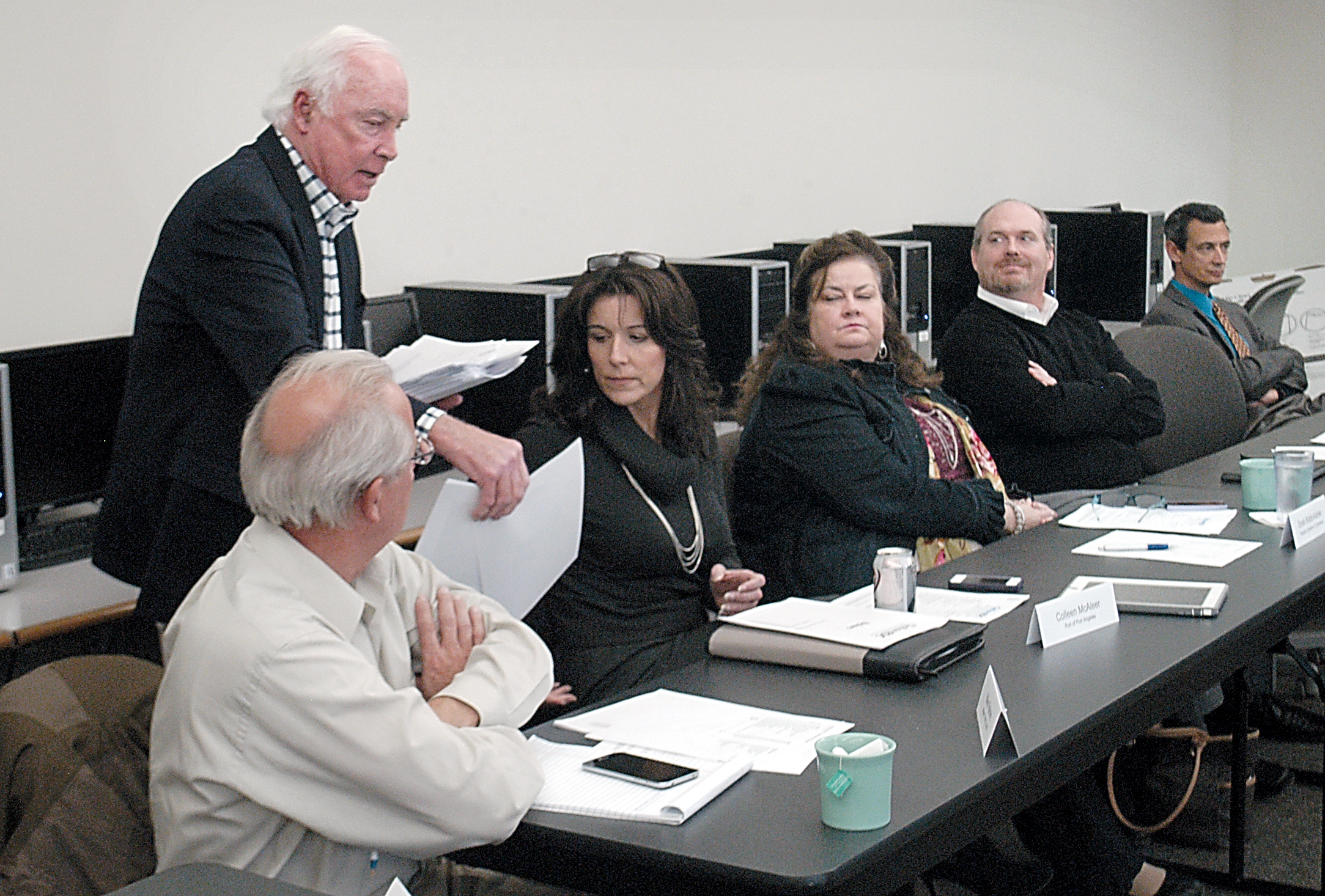 Clallam County EDC Director Bill Greenwood distributes copies of his update report to board members