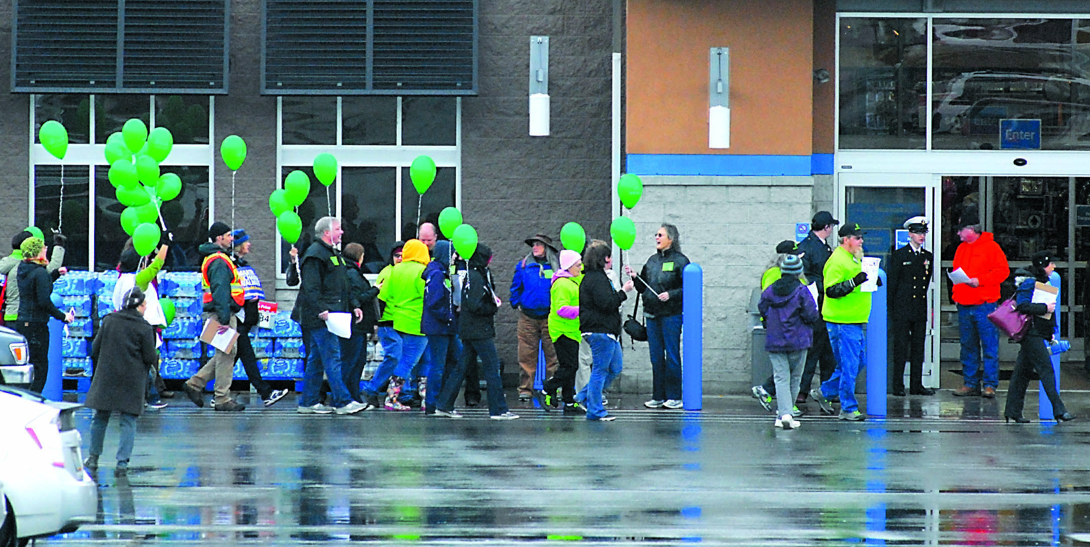 A group of people protesting corporate employee-relations practices marches in front of the Port Angeles Walmart store Friday. Keith Thorpe/Peninsula Daily News