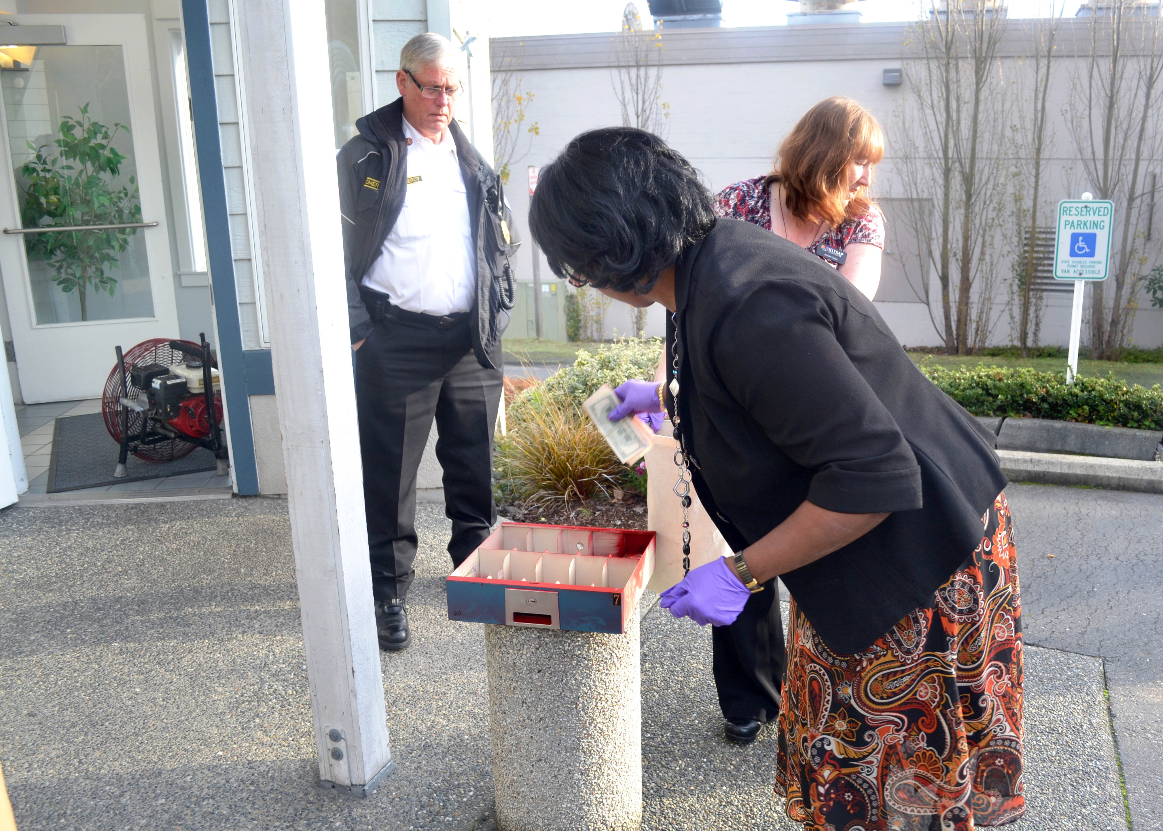 Employees of the Port Townsend Kitsap Credit Union branch remove cash from a tray following Tuesday’s incident.  -- Photo by Bill Beezley/East Jefferson Fire-Rescue