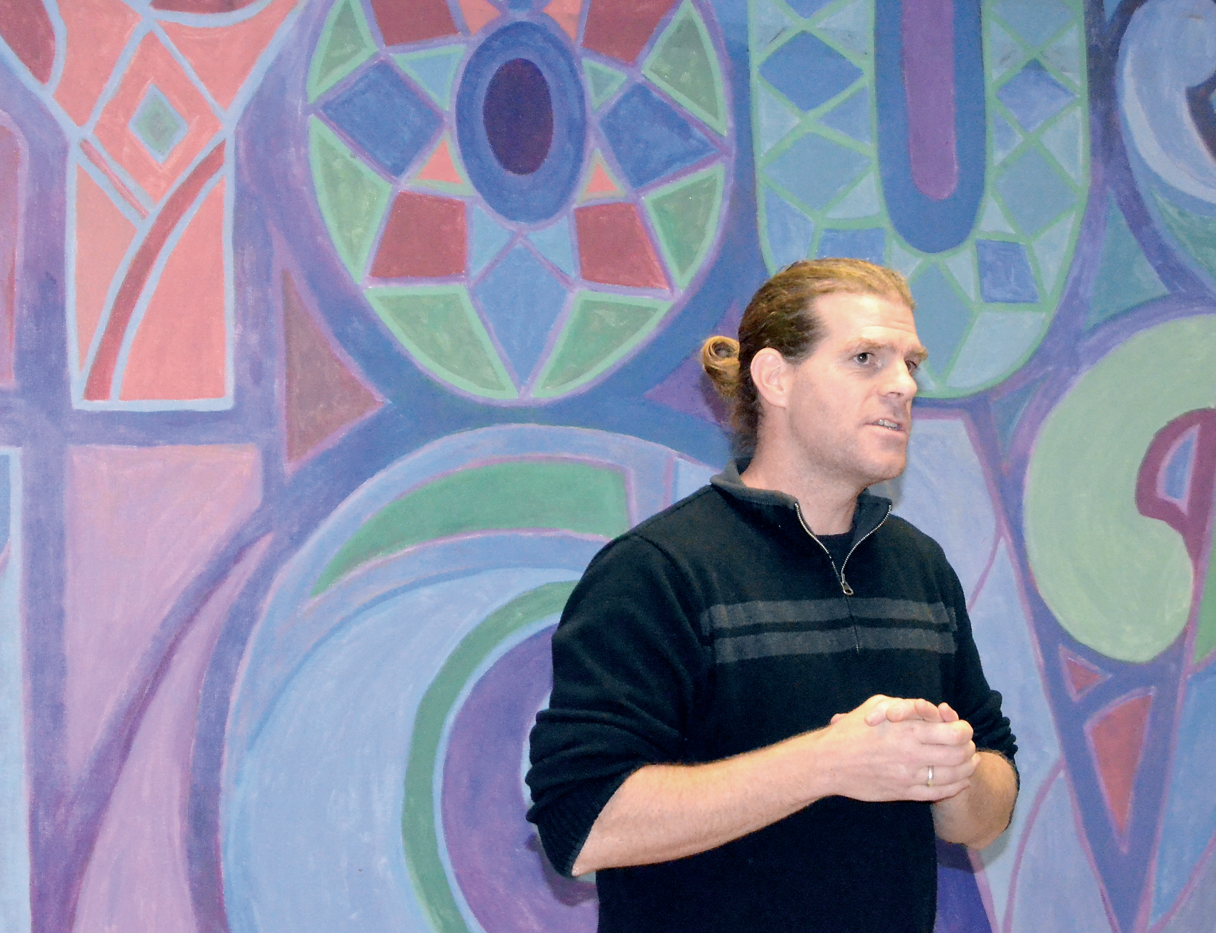 Artist Alex Cook answers questions about the “You Are Loved” mural he installed in the Port Townsend High School cafeteria. Charlie Bermant/Peninsula Daily News