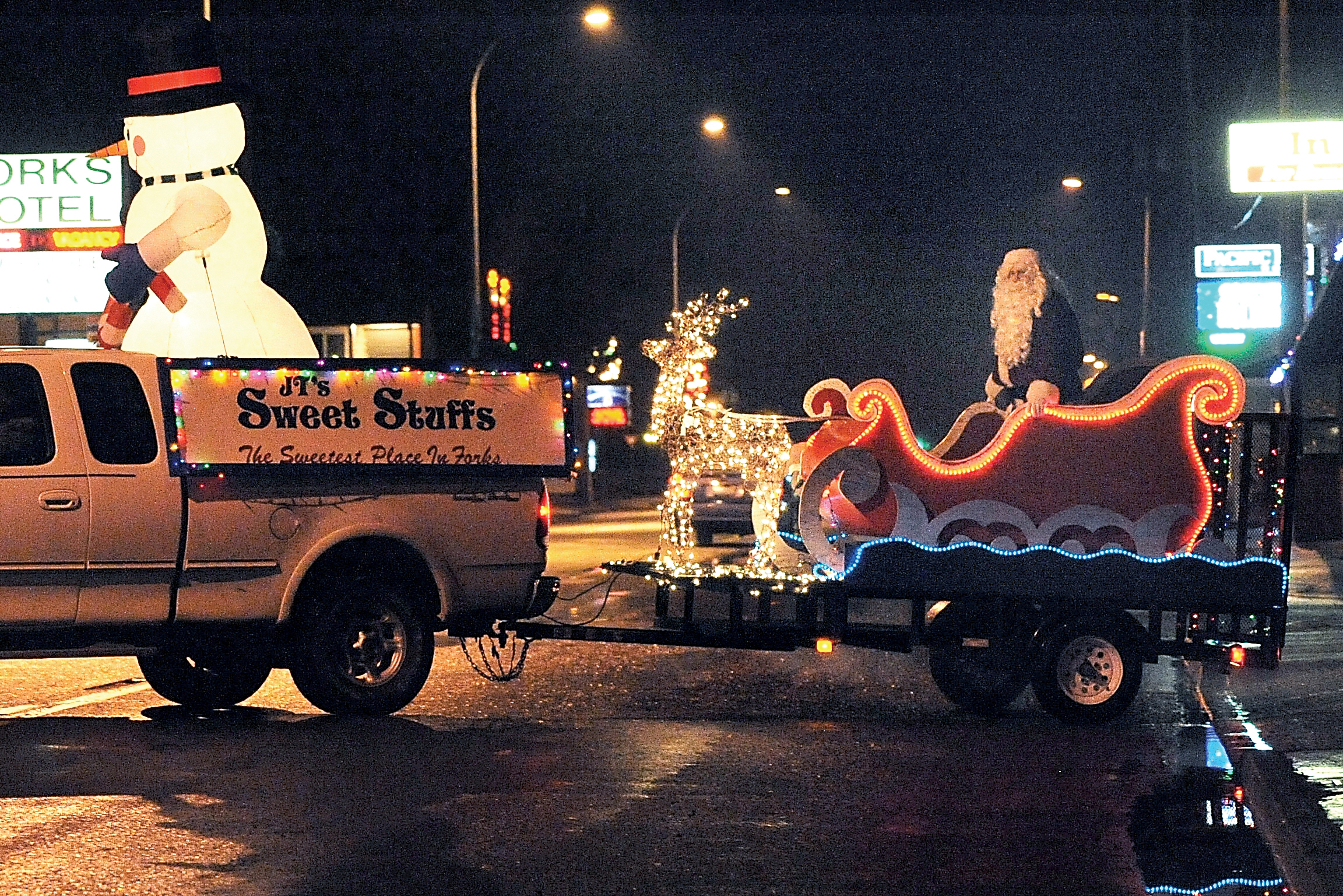 Frosty and Santa enter the parade route on the JT’s Sweet Stuffs float in Forks’ 2014 Twinkle Light Parade. — Lonnie Archibald/for Peninsula Daily News