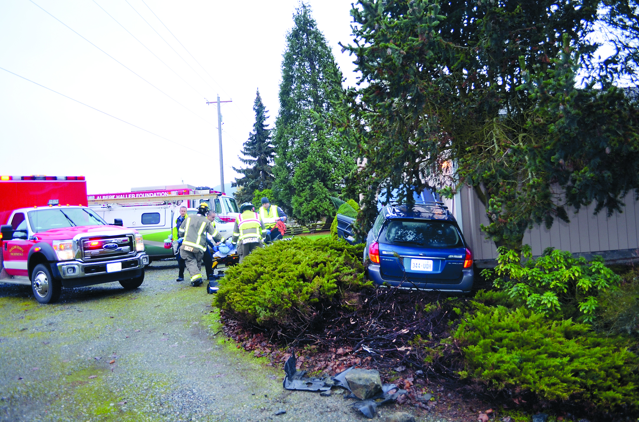 Members of Clallam County Fire District No. 3 and Olympic Ambulance prepare to transport the driver in a crash on North Kendall Road near Sequim. Clallam County Fire District No. 3